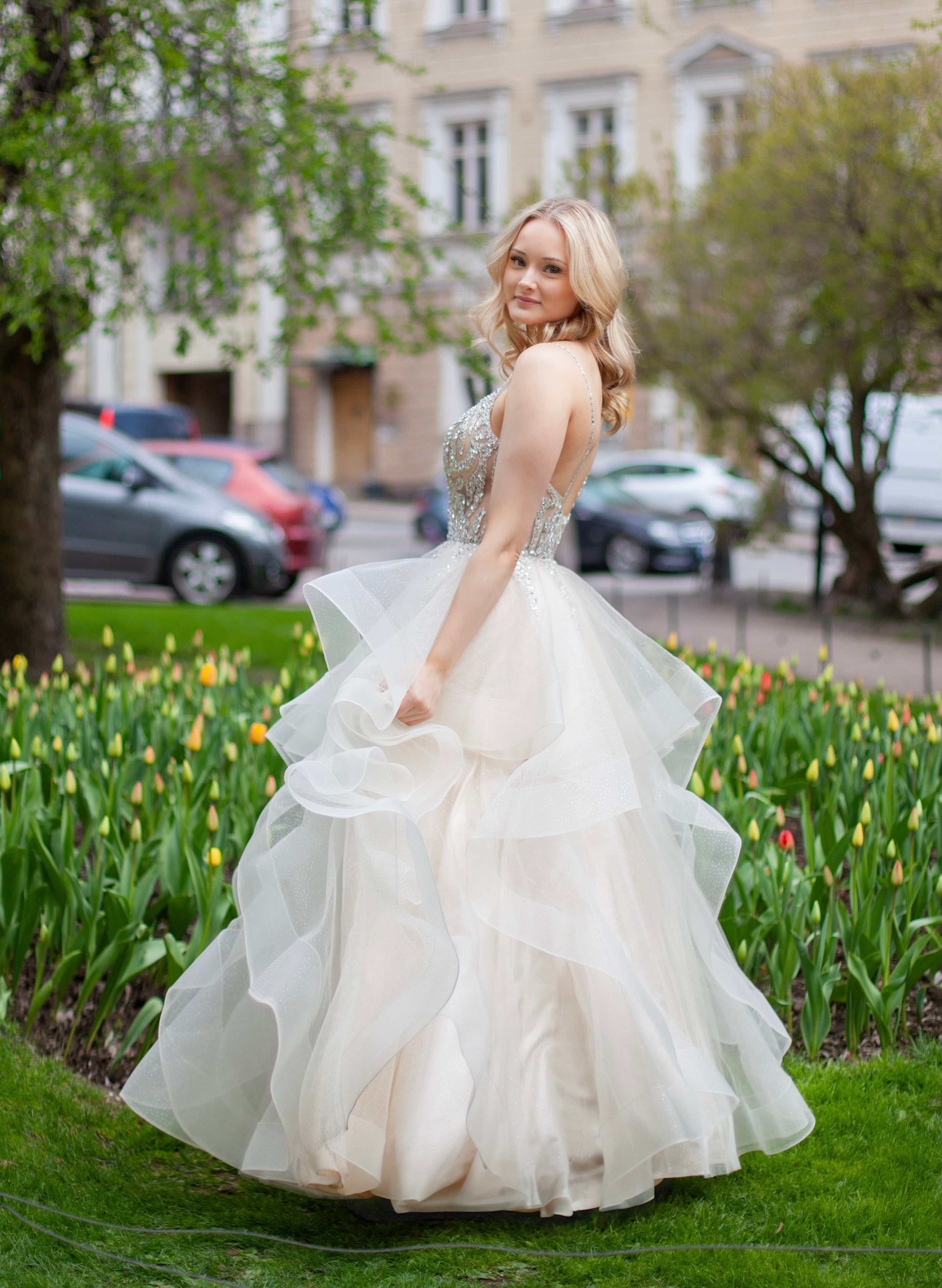 Röyhelöhelmainen vanhojentansimekko samppanjan värissä, sivusta kokokuva.