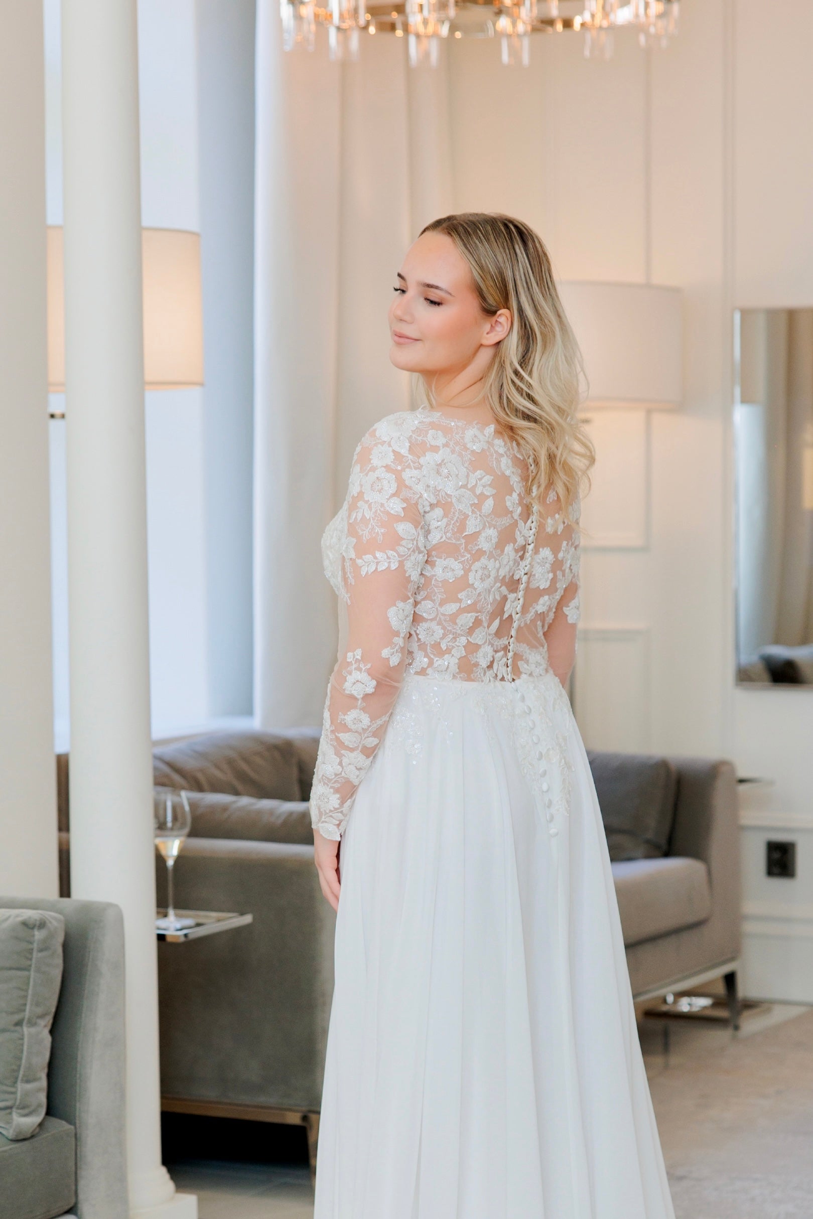 Häämekko pitsihihoilla, sifonkihelmalla ja kauniilla laahuksella, takaa.
