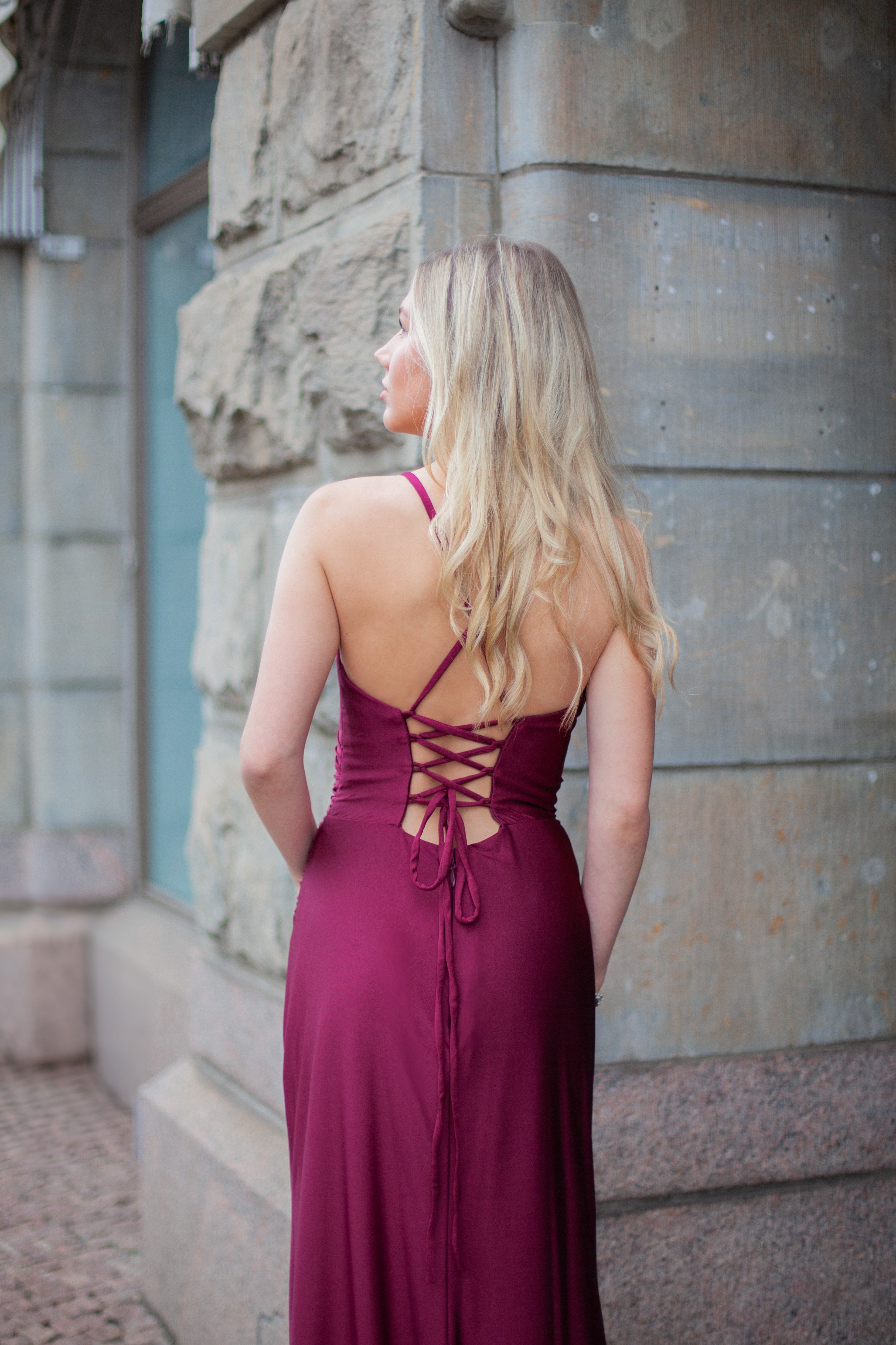 Tummanpunainen elegantti iltapuku vuosijuhliin, takaa.