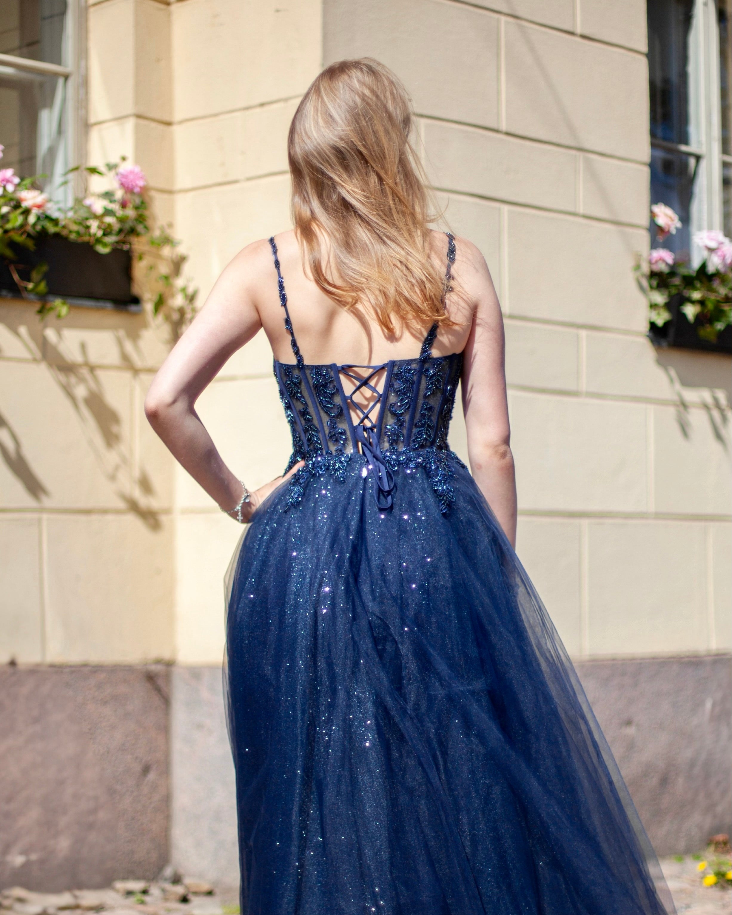 Kimaltava tummansininen vanhojentanssimekko, korsettiyläosa, lähikuva takaa.