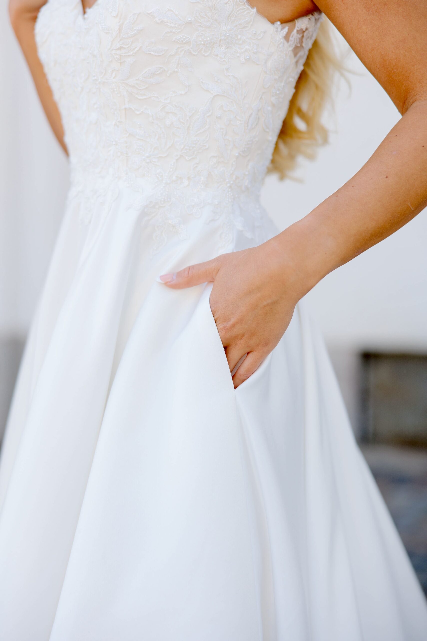 Dazzling-häämekko satiinia, pitsiyläosa V-kaula-aukolla, elegantti ja juhlava, lähikuva.