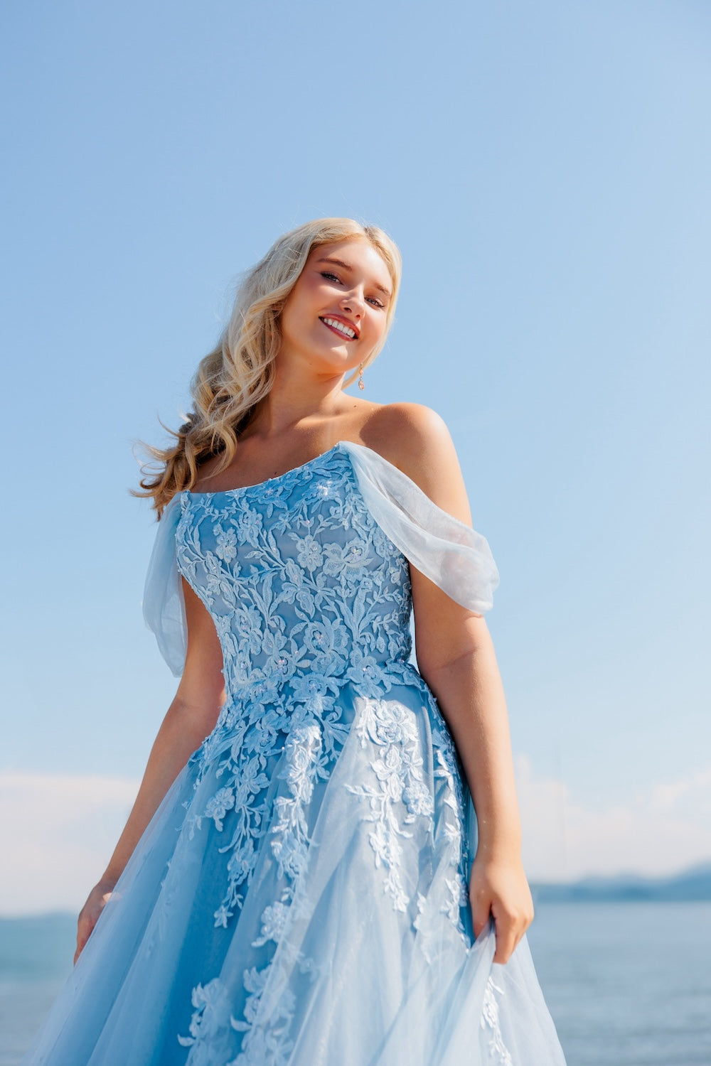 Siniharmaa vanhojentanssimekko off shoulder -olkaimilla, pitsiyläosalla ja tyllihelmalla, lähikuva.