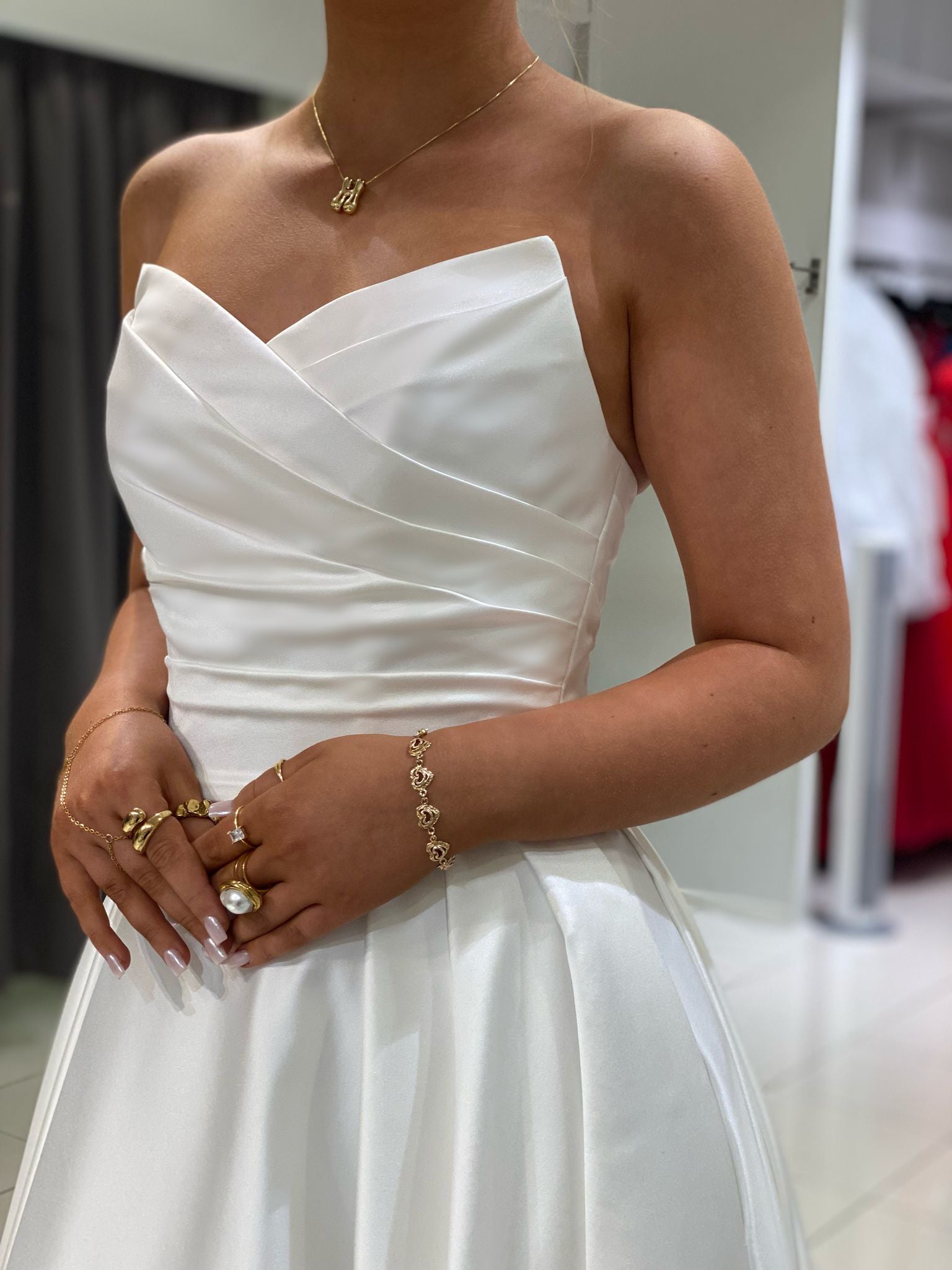 Olkaimeton klassinen häämekko, laskostettu yläosa ja täyteläinen helma, elegantti ja romanttinen, lähikuva.