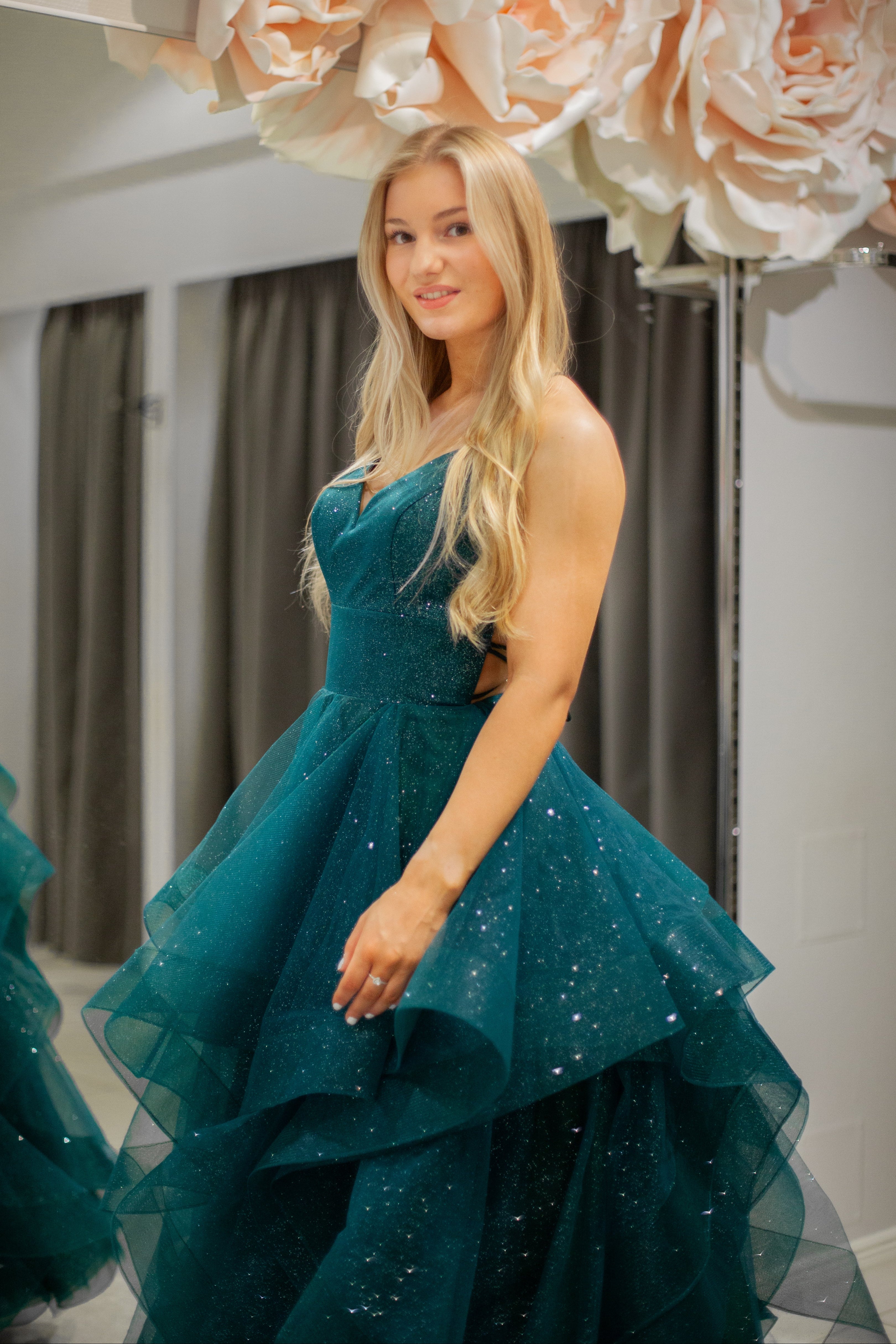 Tummanvihreä vanhojentanssimekko kimaltava, röyhelöhelma ja narunyöri.