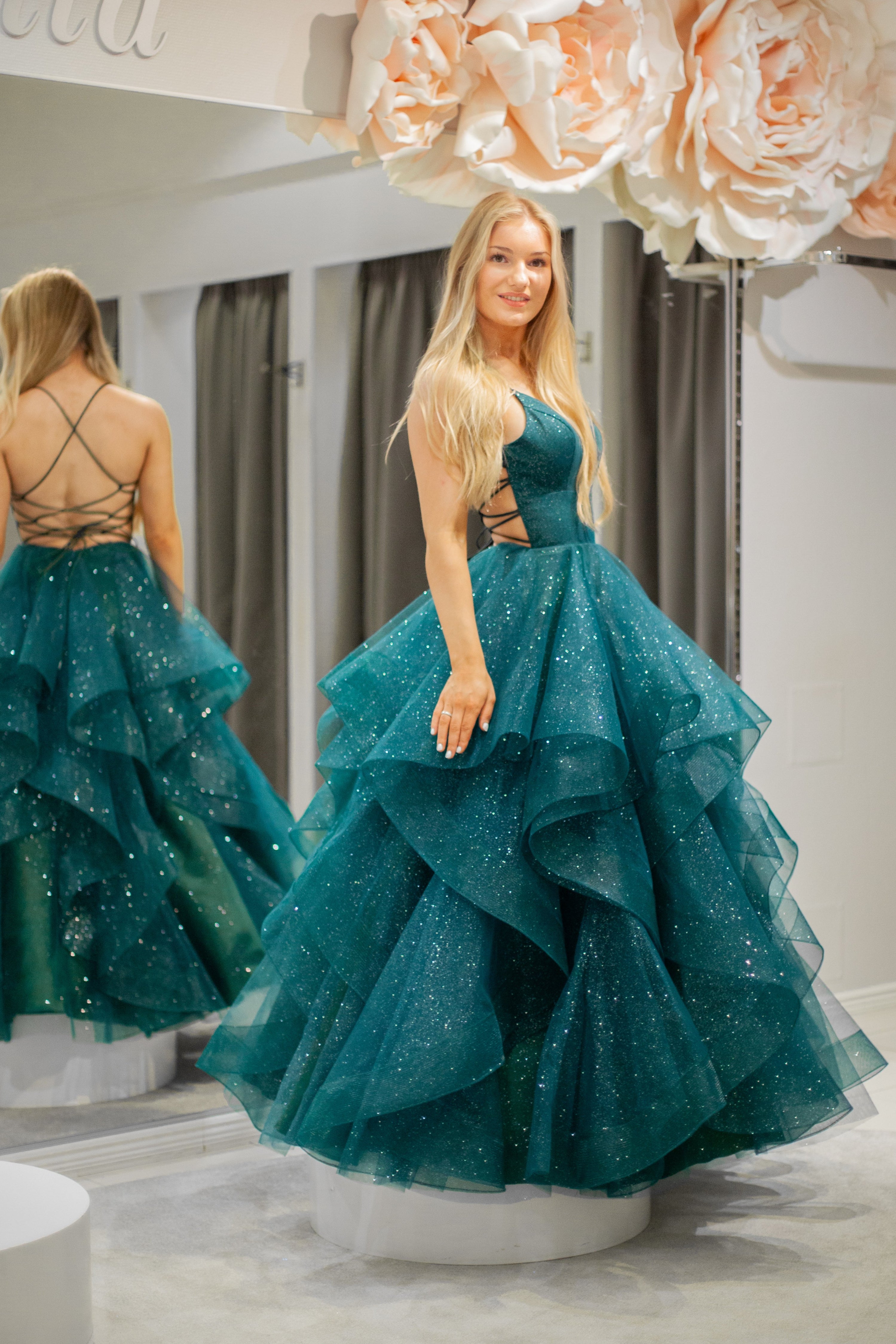 Tummanvihreä vanhojentanssimekko kimaltava, röyhelöhelma ja narunyöri.