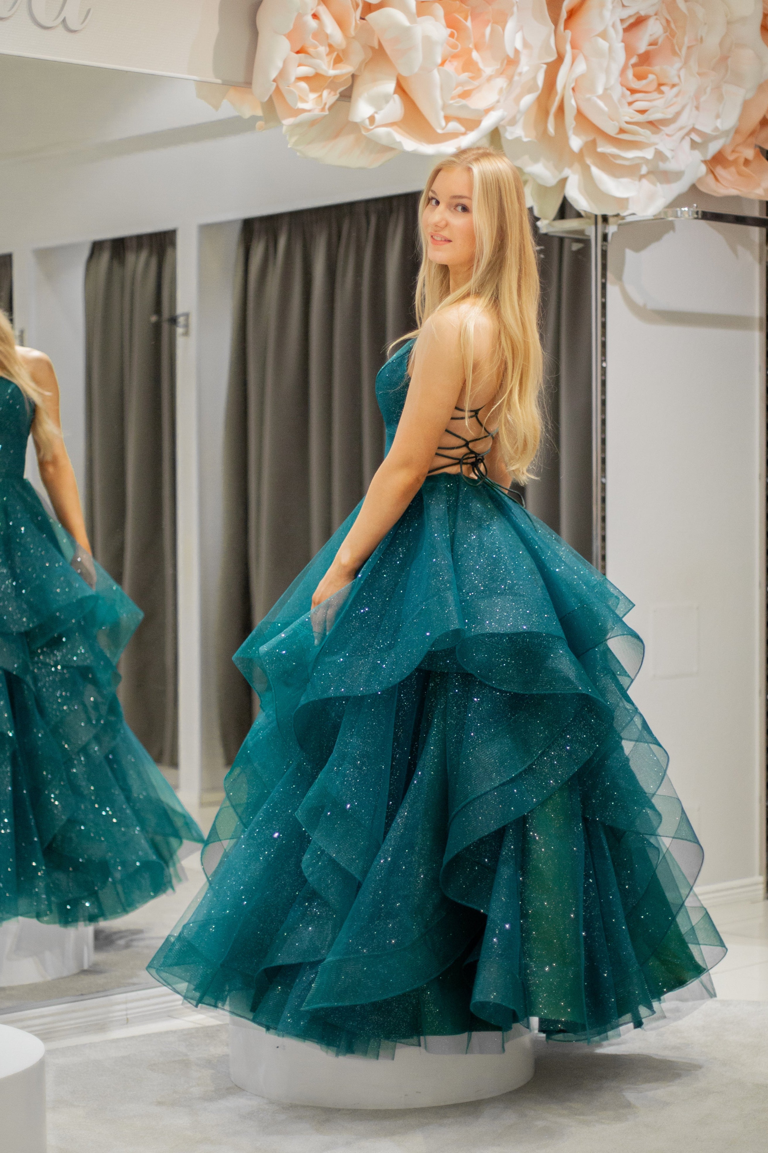 Tummanvihreä vanhojentanssimekko kimaltava, röyhelöhelma ja narunyöri.