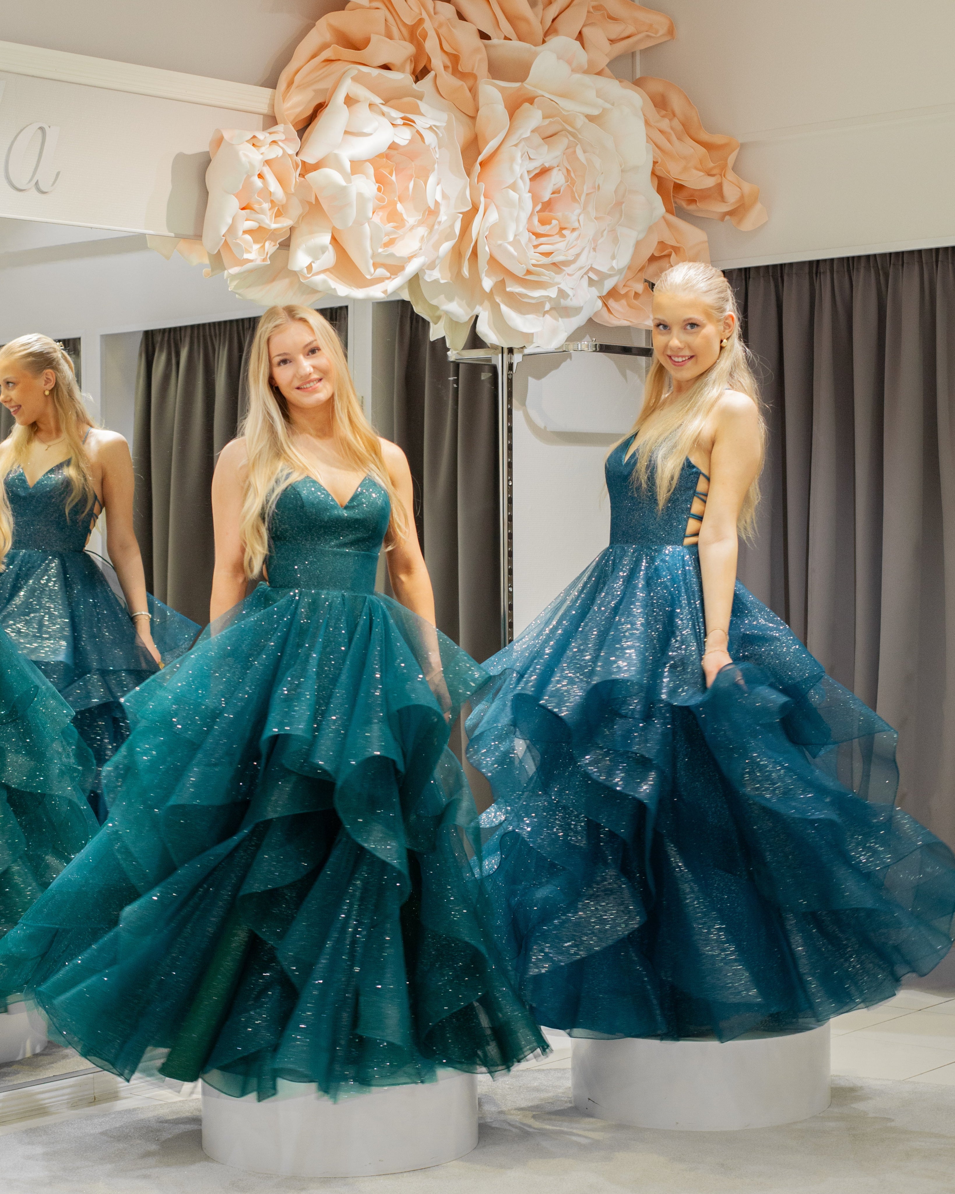 Tummanvihreä ja petrol vanhojentanssimekko kimaltava, röyhelöhelma ja narunyöri.