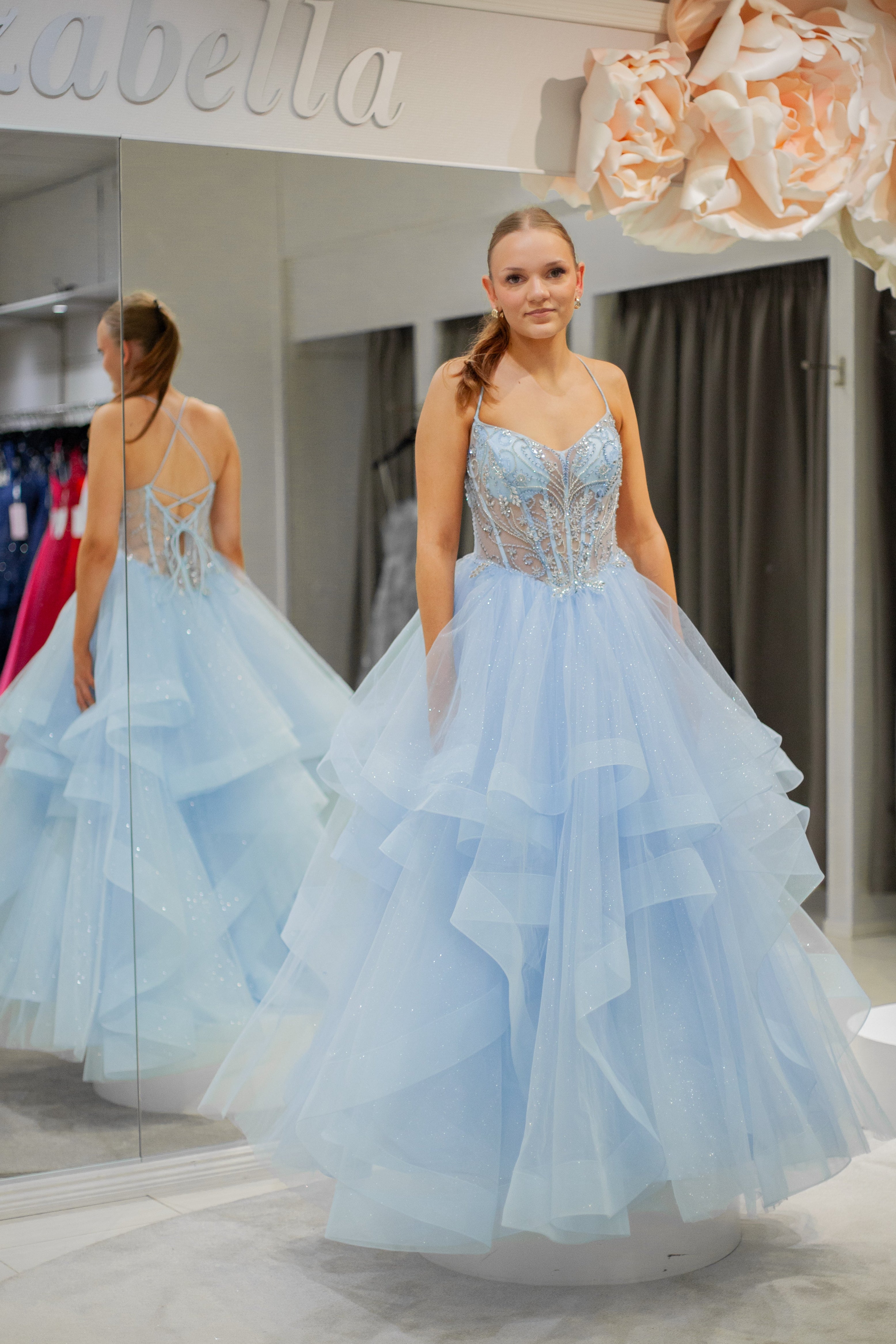 Vaaleansininen kimaltava vanhojentanssimekko röyhelöhelmalla ja kirjailulla yläosalla, edestä.