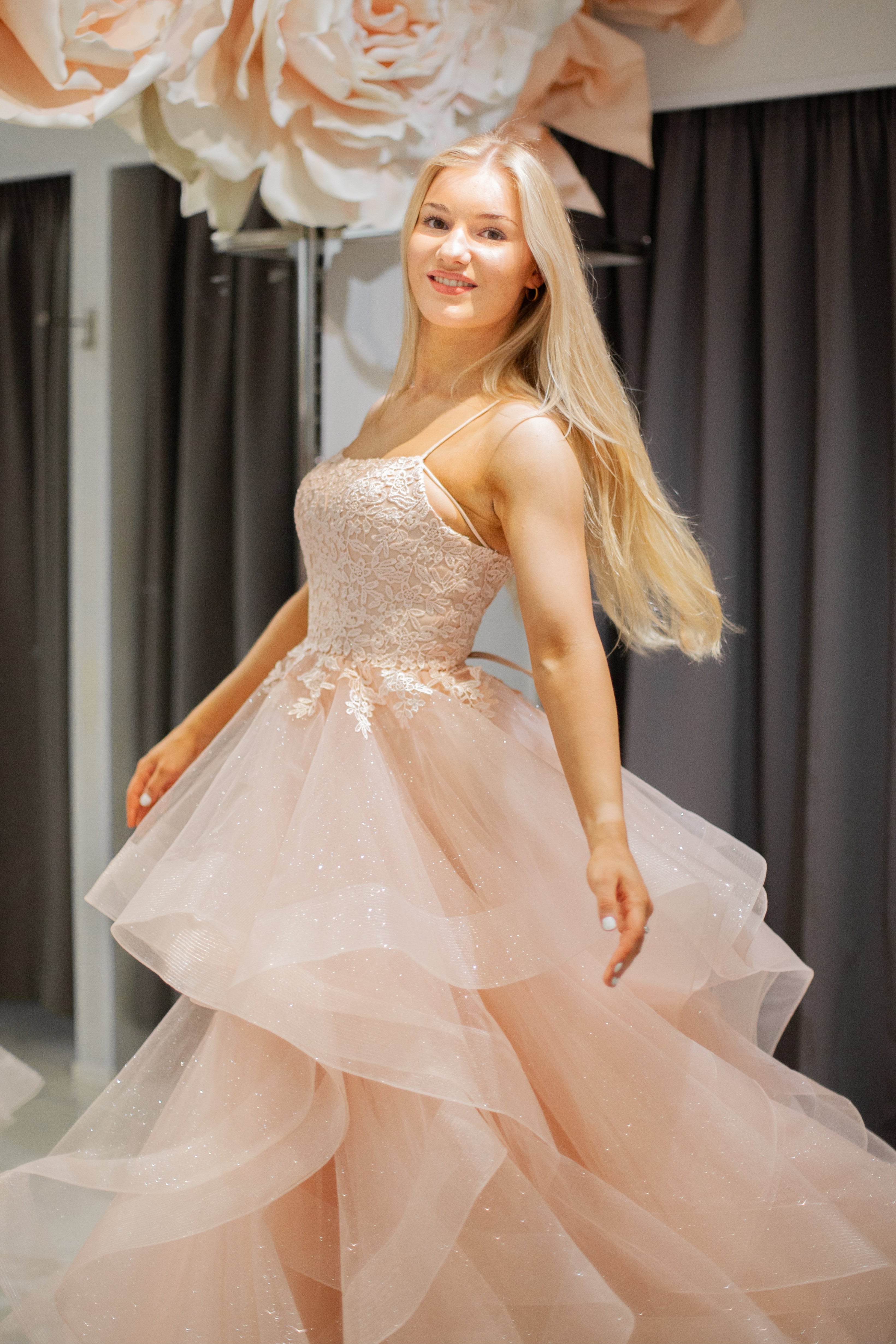 Vaalearosa vanhojentanssimekko pitsiyläosalla ja röyhelöhelmalla.