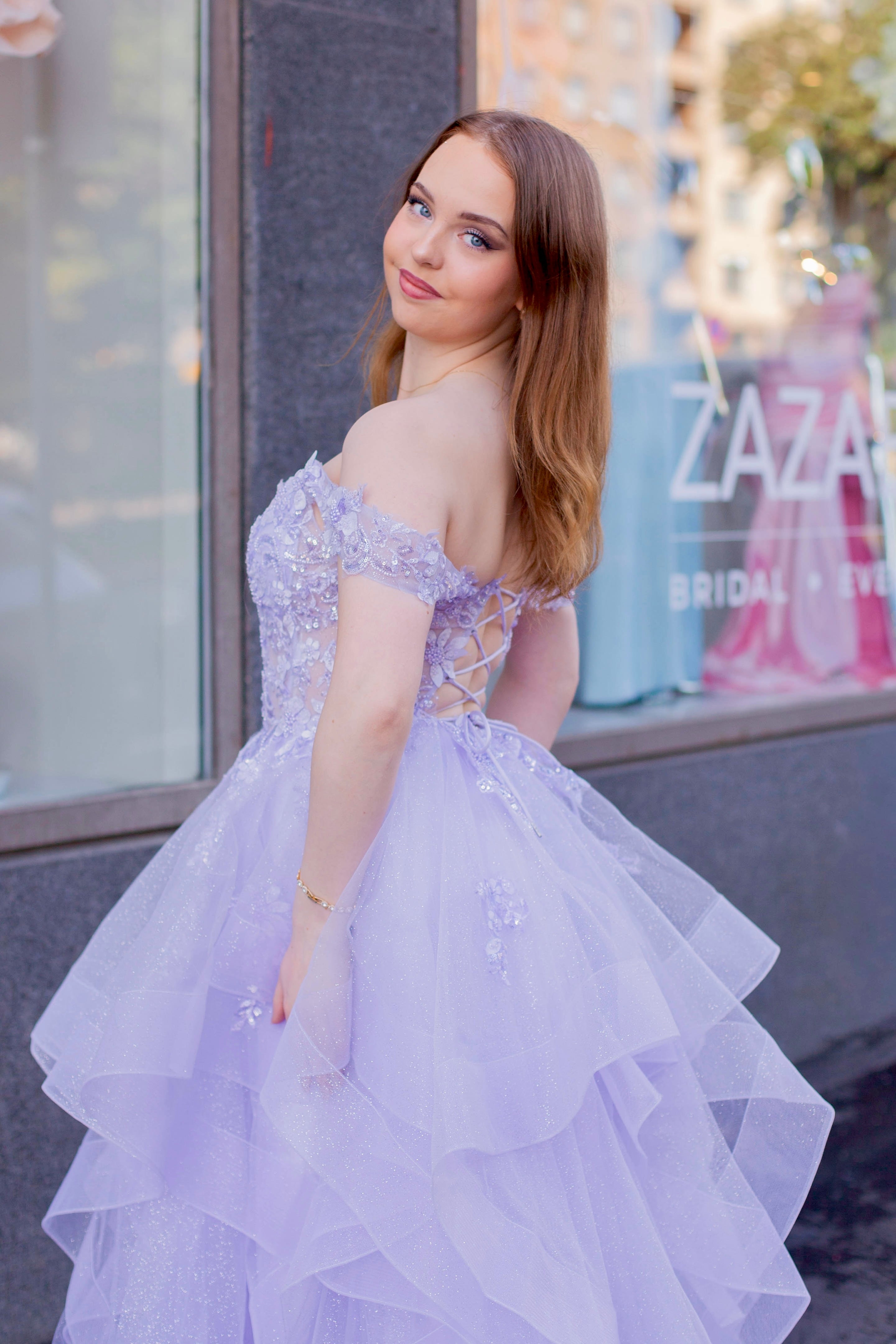 Violetti kimaltava vanhojentanssimekko off shoulder -yläosalla ja röyhelöhelmalla.