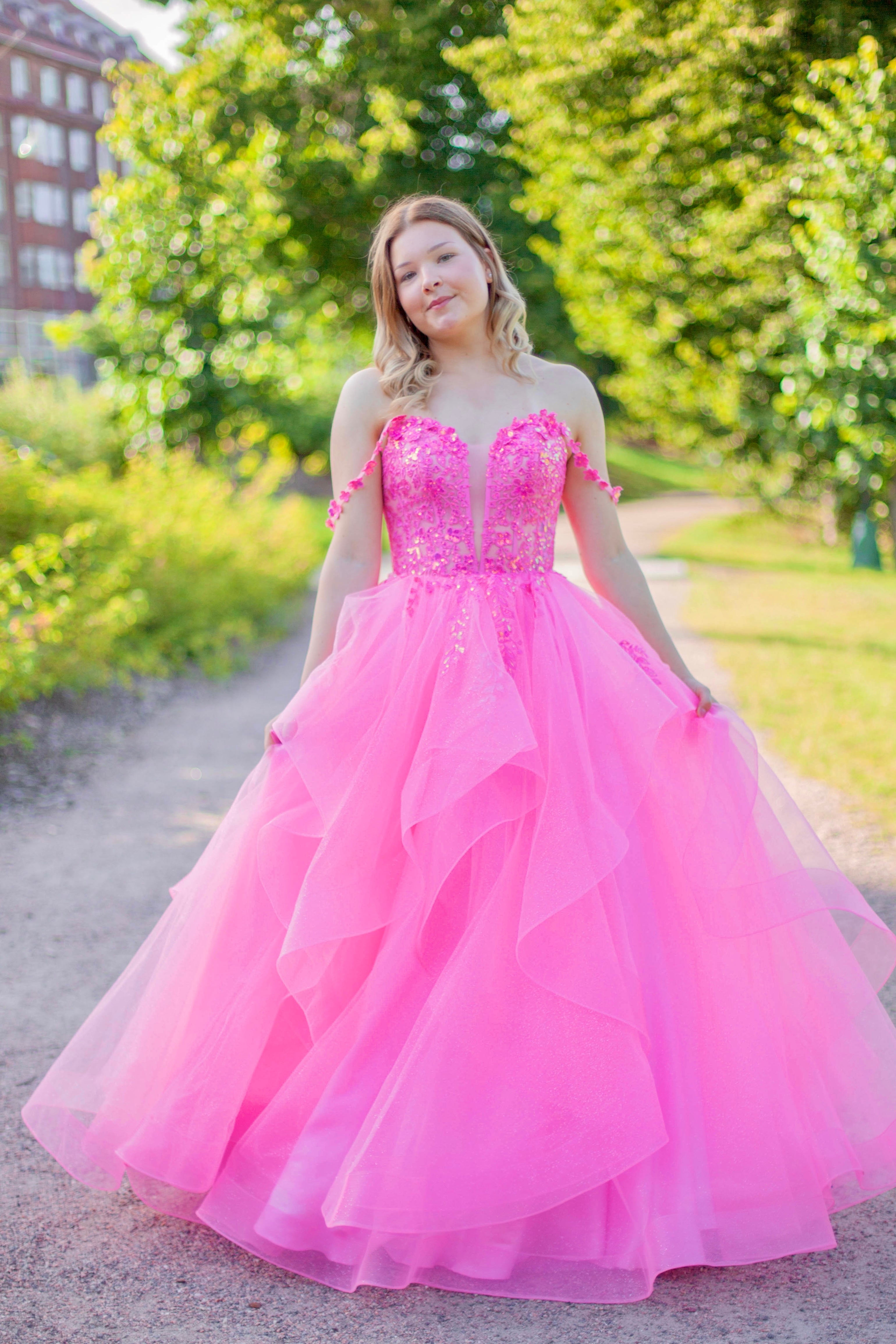Pinkki vanhojentanssimekko röyhelöhelmalla ja off shoulder olkaimella.