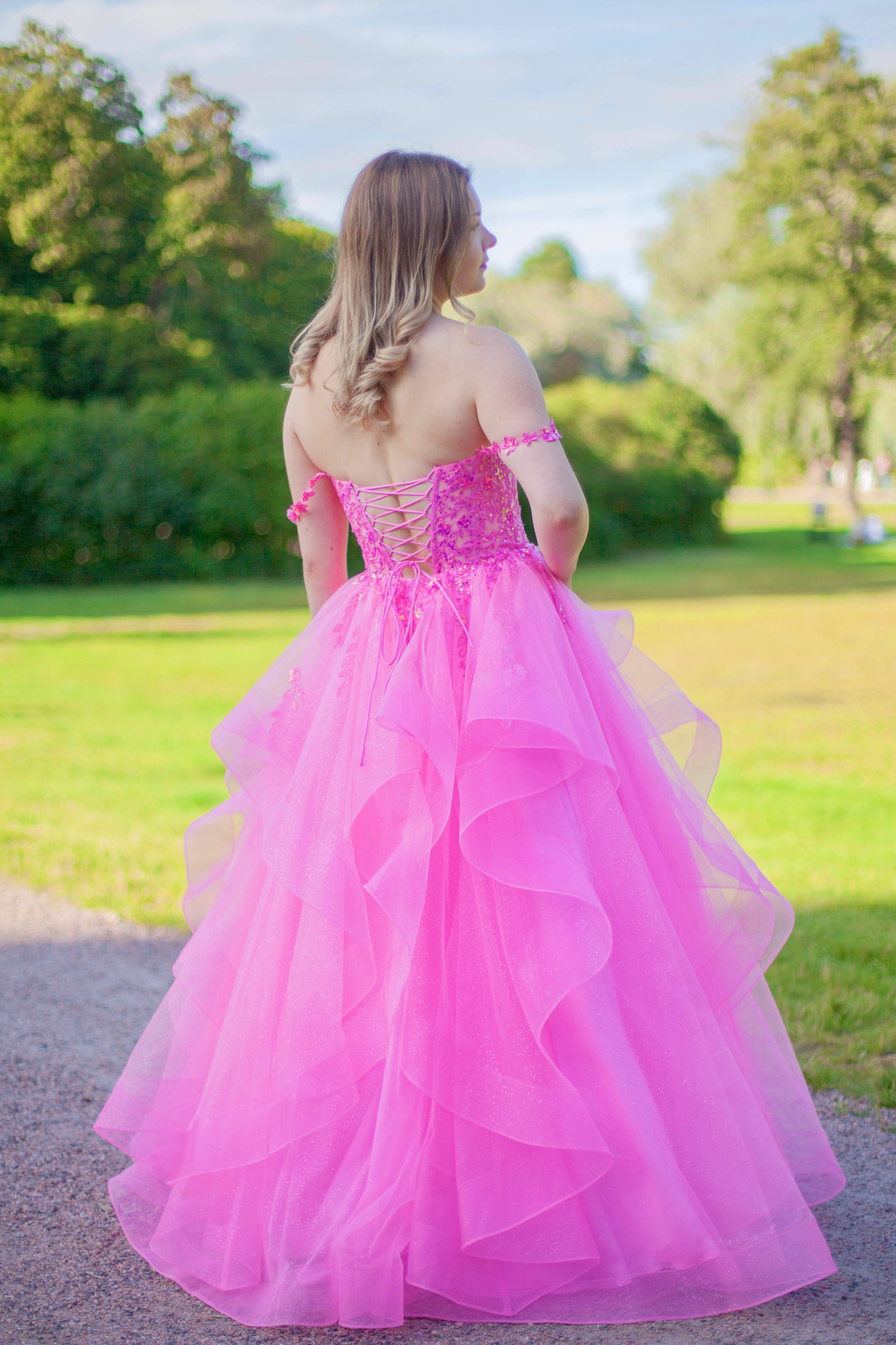 Pinkki vanhojentanssimekko röyhelöhelmalla ja off shoulder olkaimella.