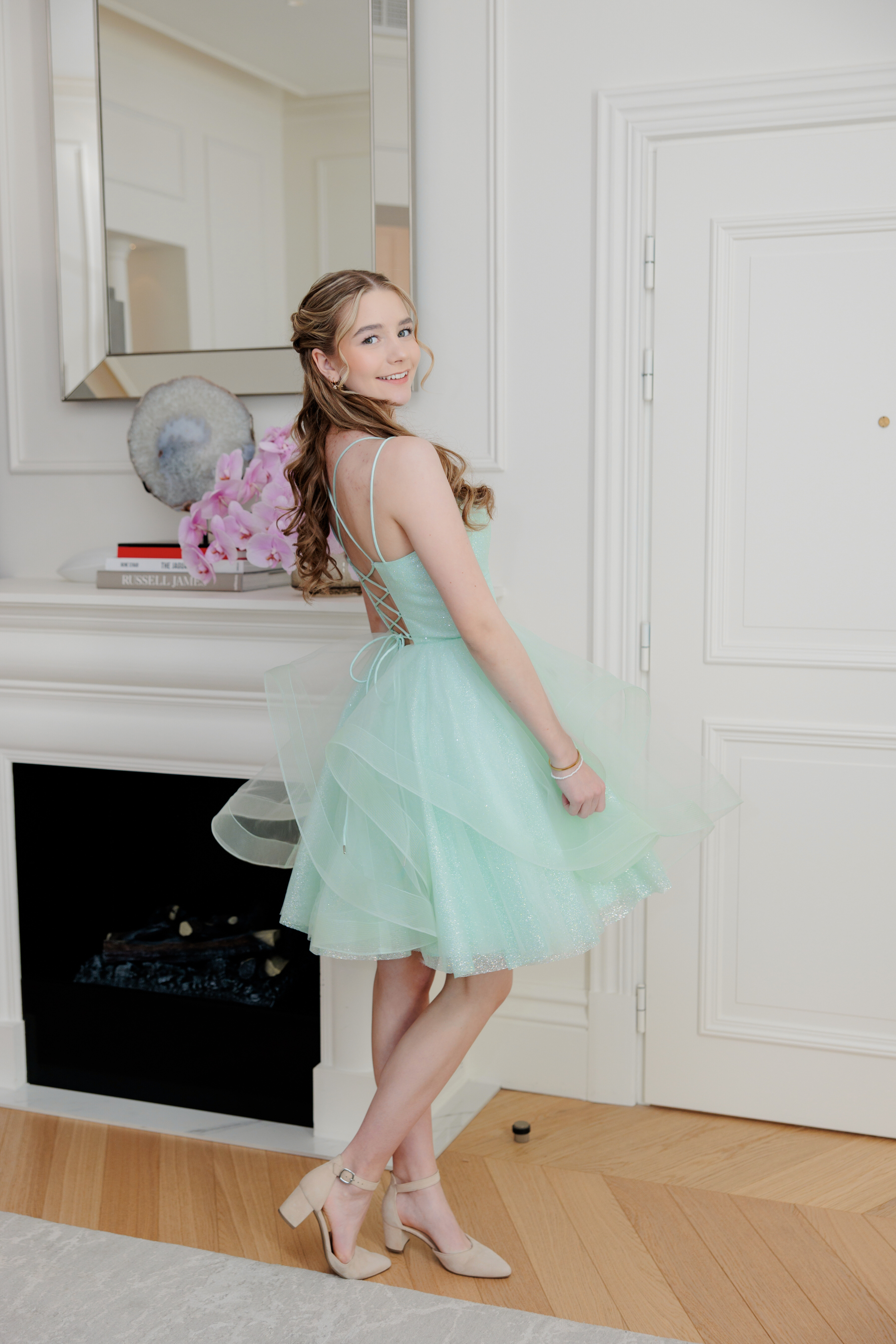 Mintun värinen juhlamekko röyhelöhelmalla ja kimalluksella, takaa.