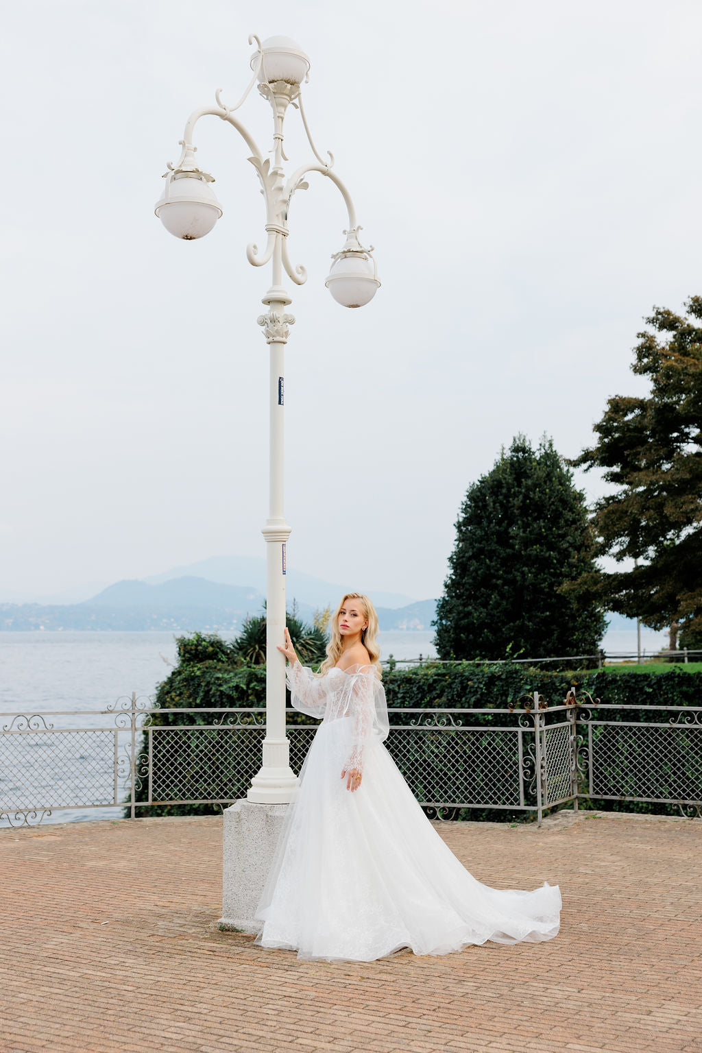 Häämekko korsettimaisella yläosalla ja pitsisillä hihoilla.