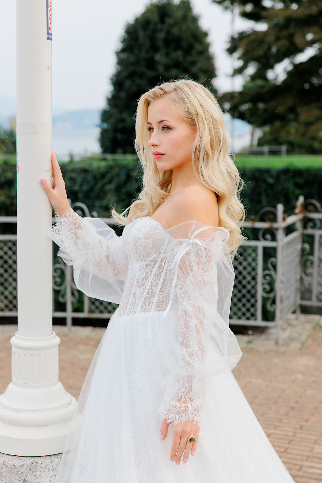 Häämekko korsettimaisella yläosalla ja pitsisillä hihoilla.