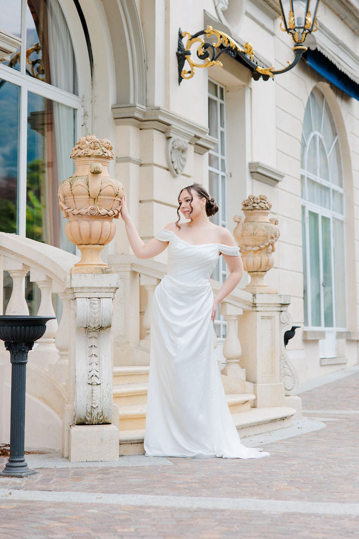 Laskeutuva off shoulder -häämekko tyköistuvalla yläosalla.