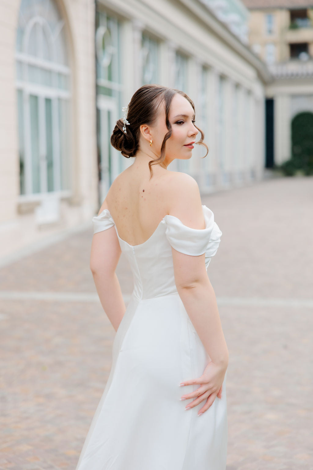 Laskeutuva off shoulder -häämekko tyköistuvalla yläosalla, takaa.