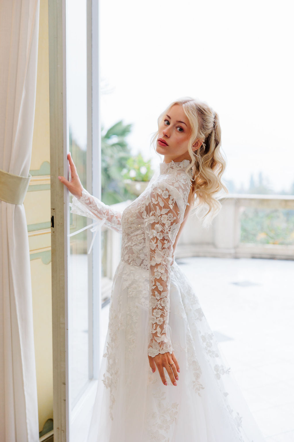 Häämekko, jossa pitkät hihat ja romanttinen pitsiyksityiskohta.