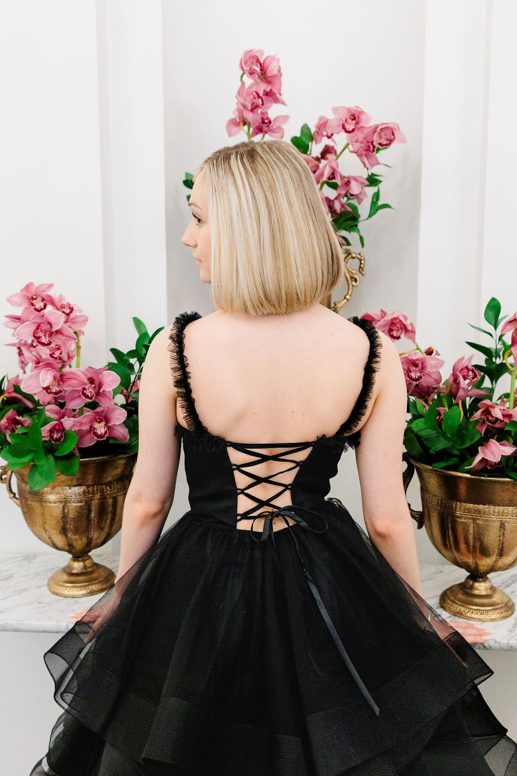 Musta vanhojentanssimekko röyhelöhelmalla,takaa.