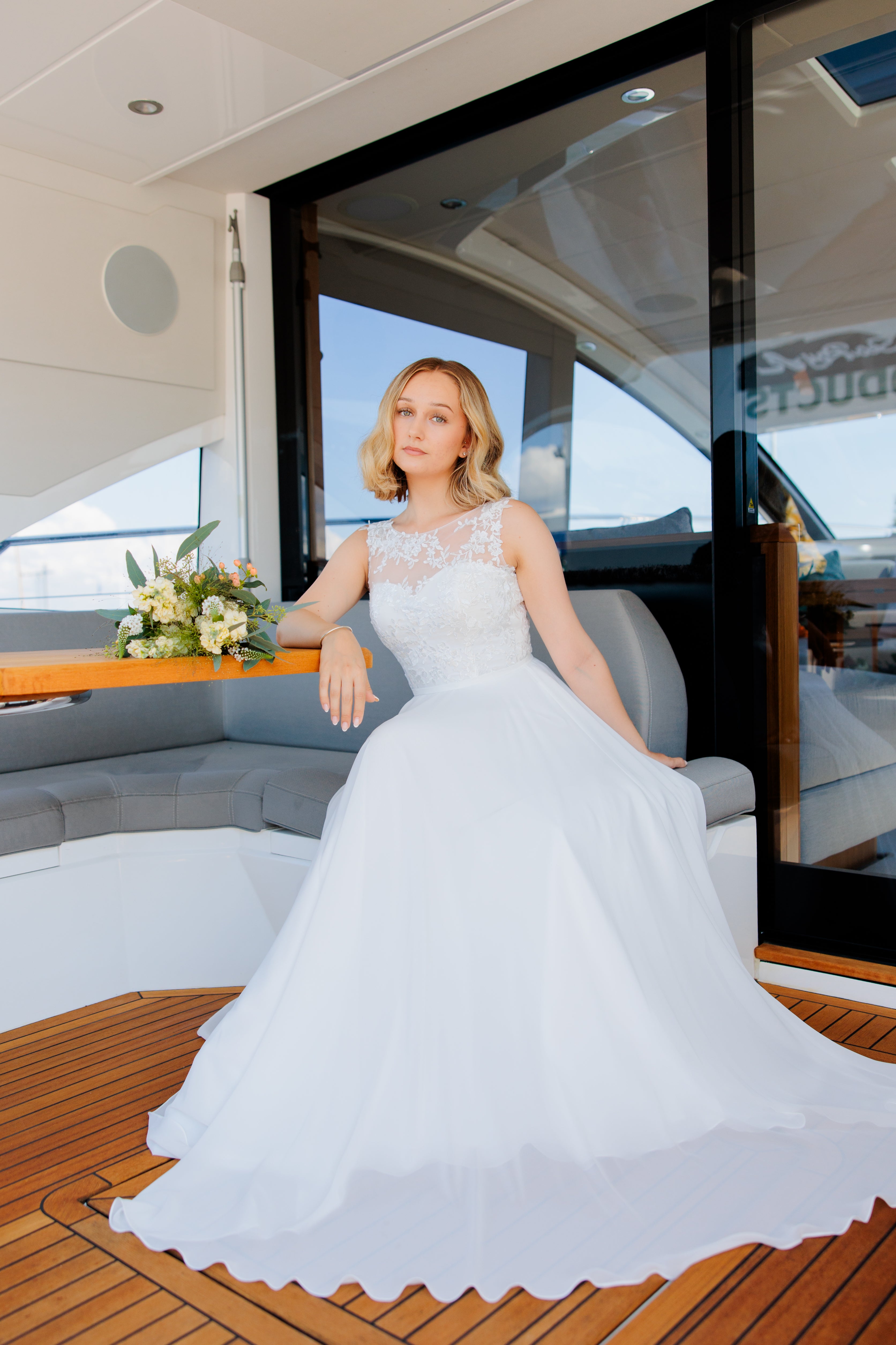 Sifonkinen häämekko, pitsiyläosa ja kevyt laskeutuva kangas, elegantti, edestä.