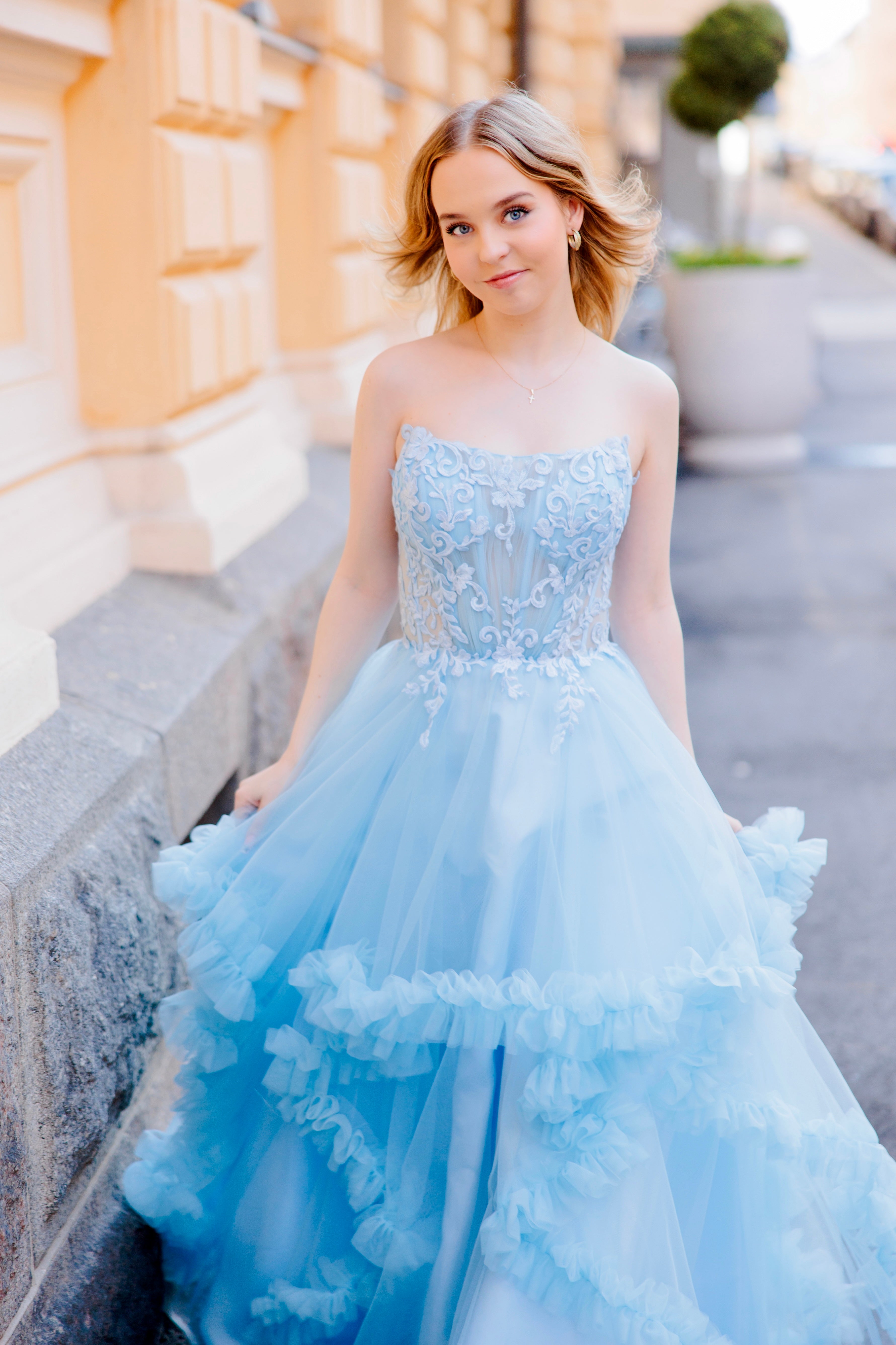 Olkaimeton vaaleansininen röyhelähelmainen vanhojentanssimekko, etukuva läheltä.