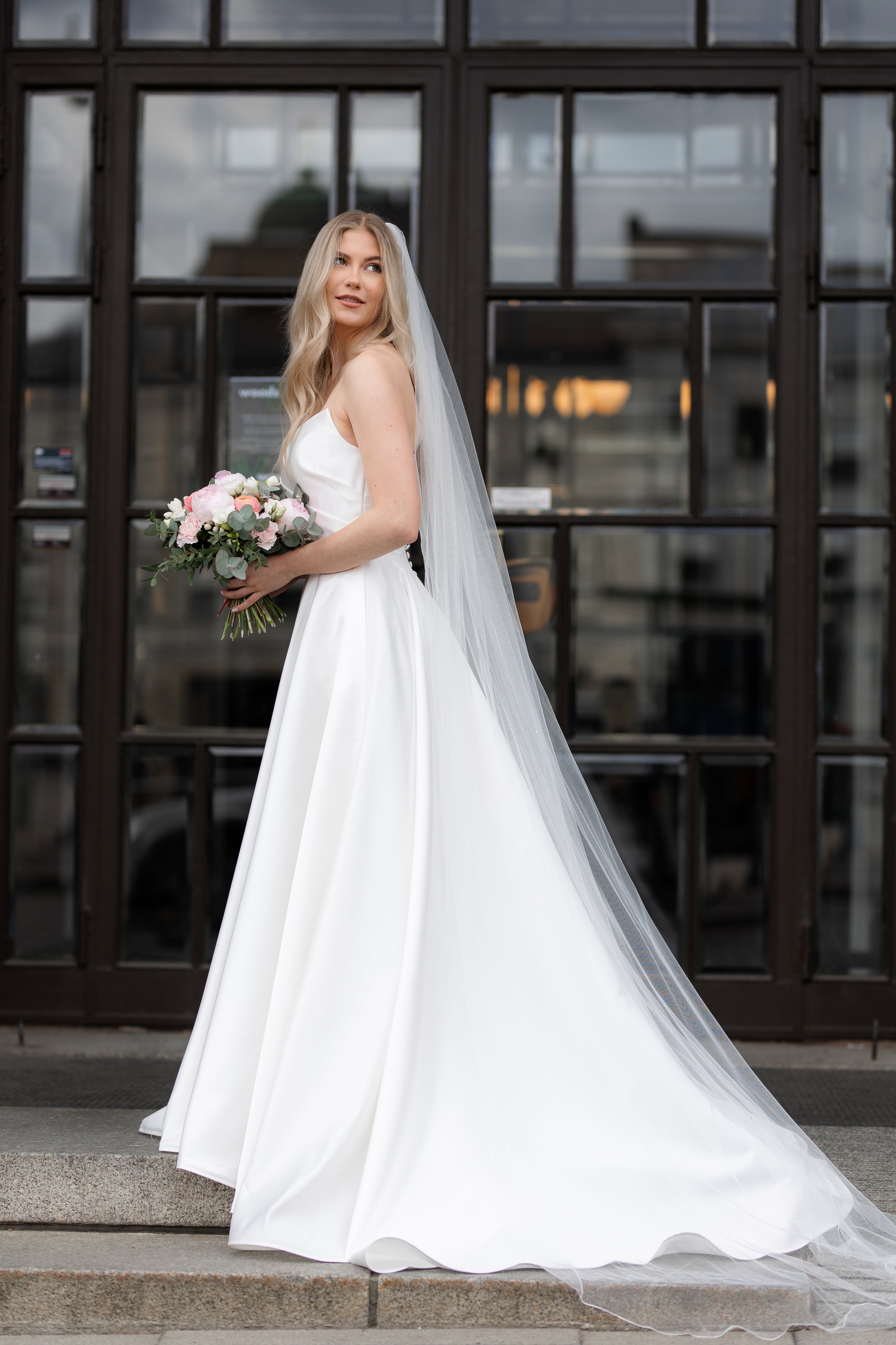 Olkaimeton satiininen häämekko klassisella A-linjaisella leikkauksella, sivusta.