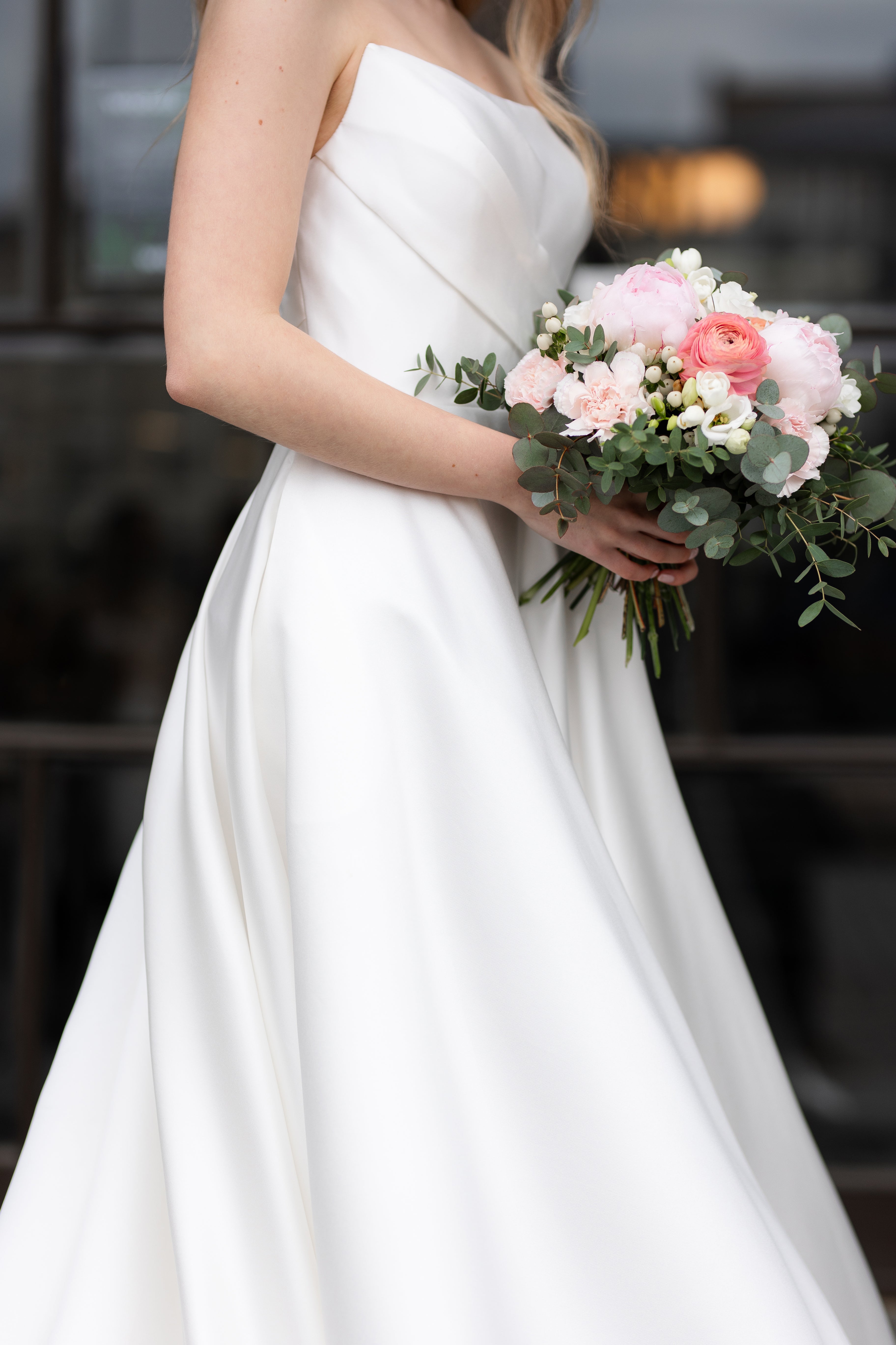 Olkaimeton satiininen häämekko klassisella A-linjaisella leikkauksella, sivusta.