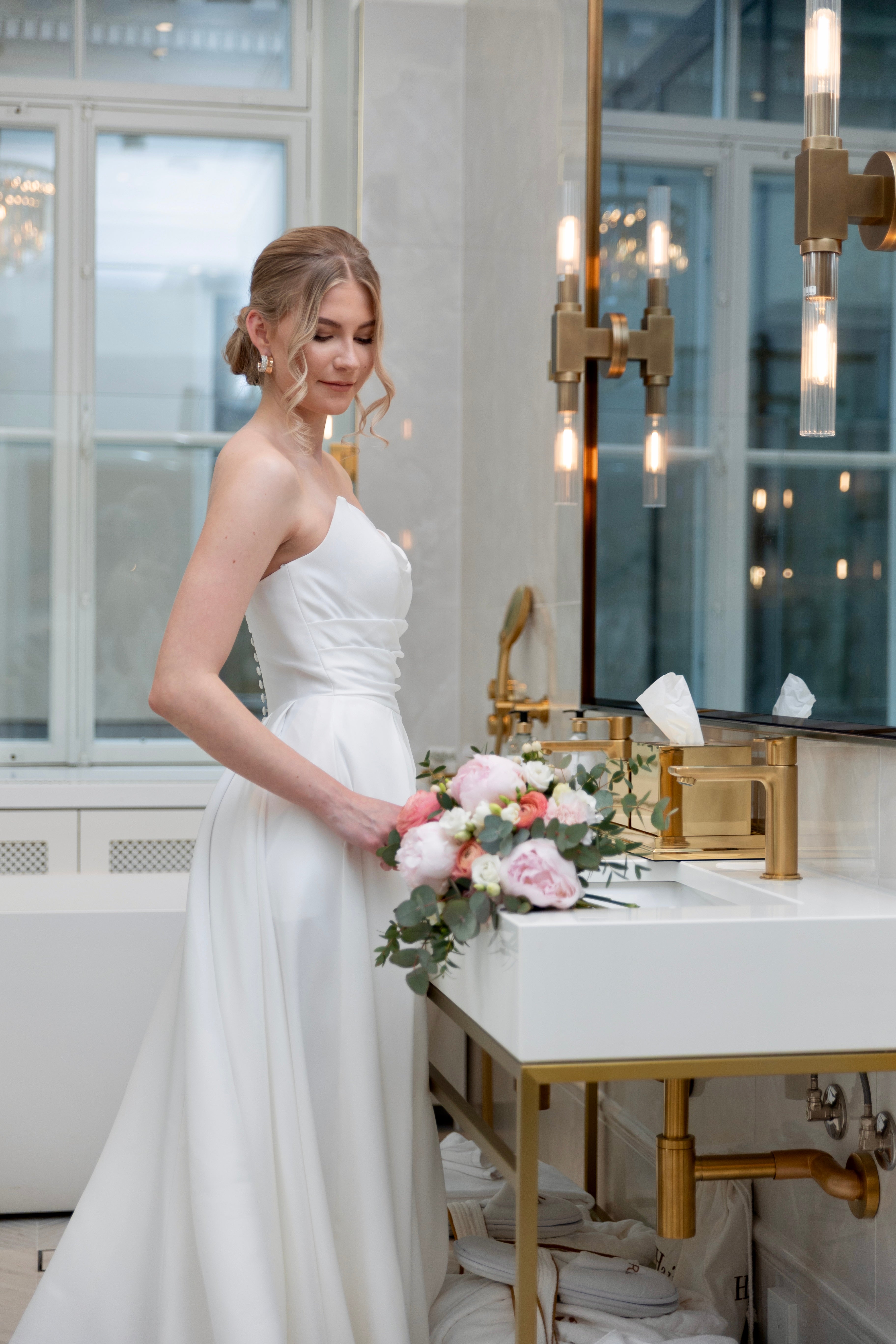 Häämekko laskeutuvalla materiaalilla ja rypytyksellä, klassinen siluetti ja moderni tyyli, sivusta.