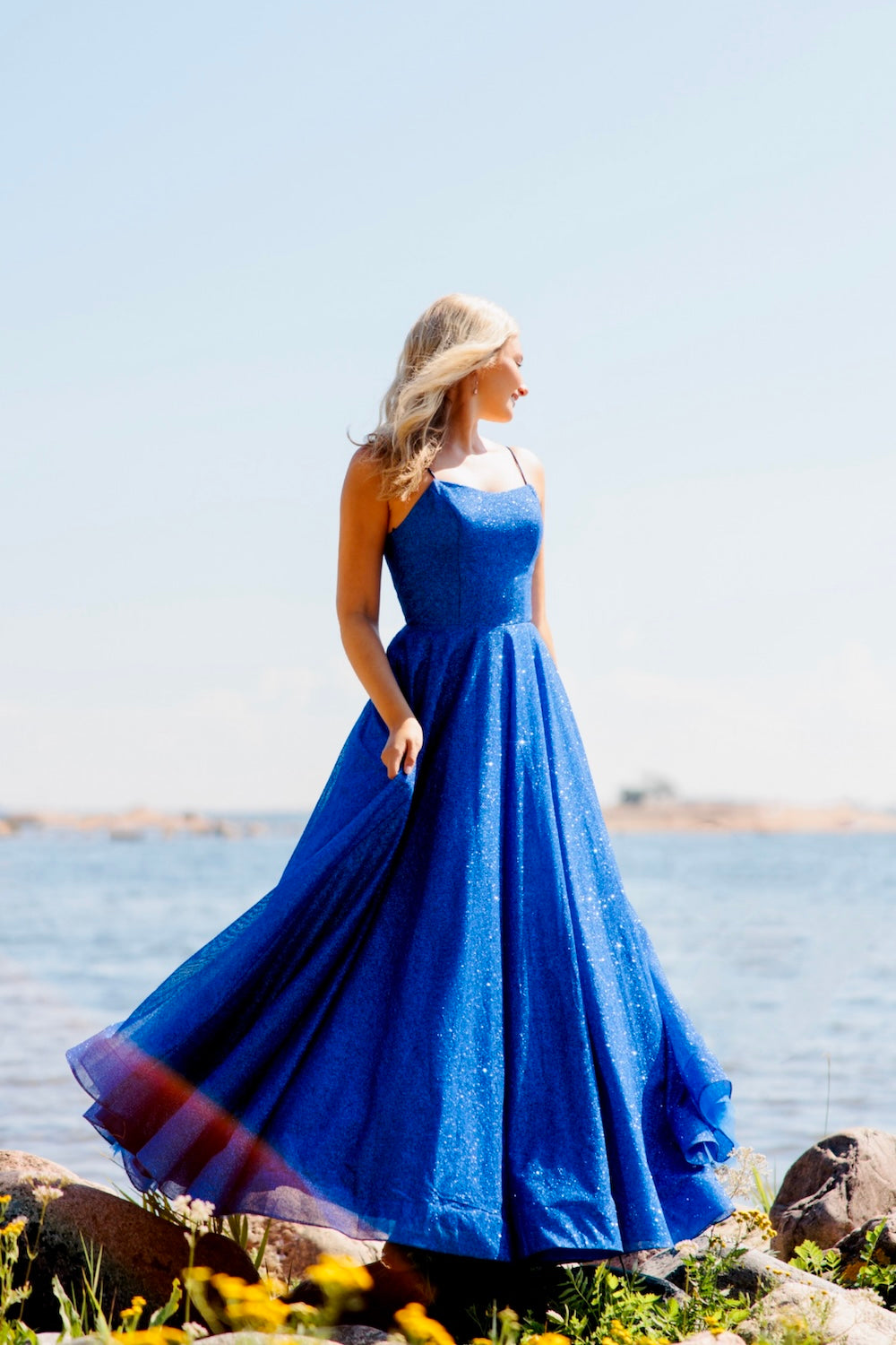 Kirkkaan sininen kimaltava vanhojentanssimekko, sivusta.