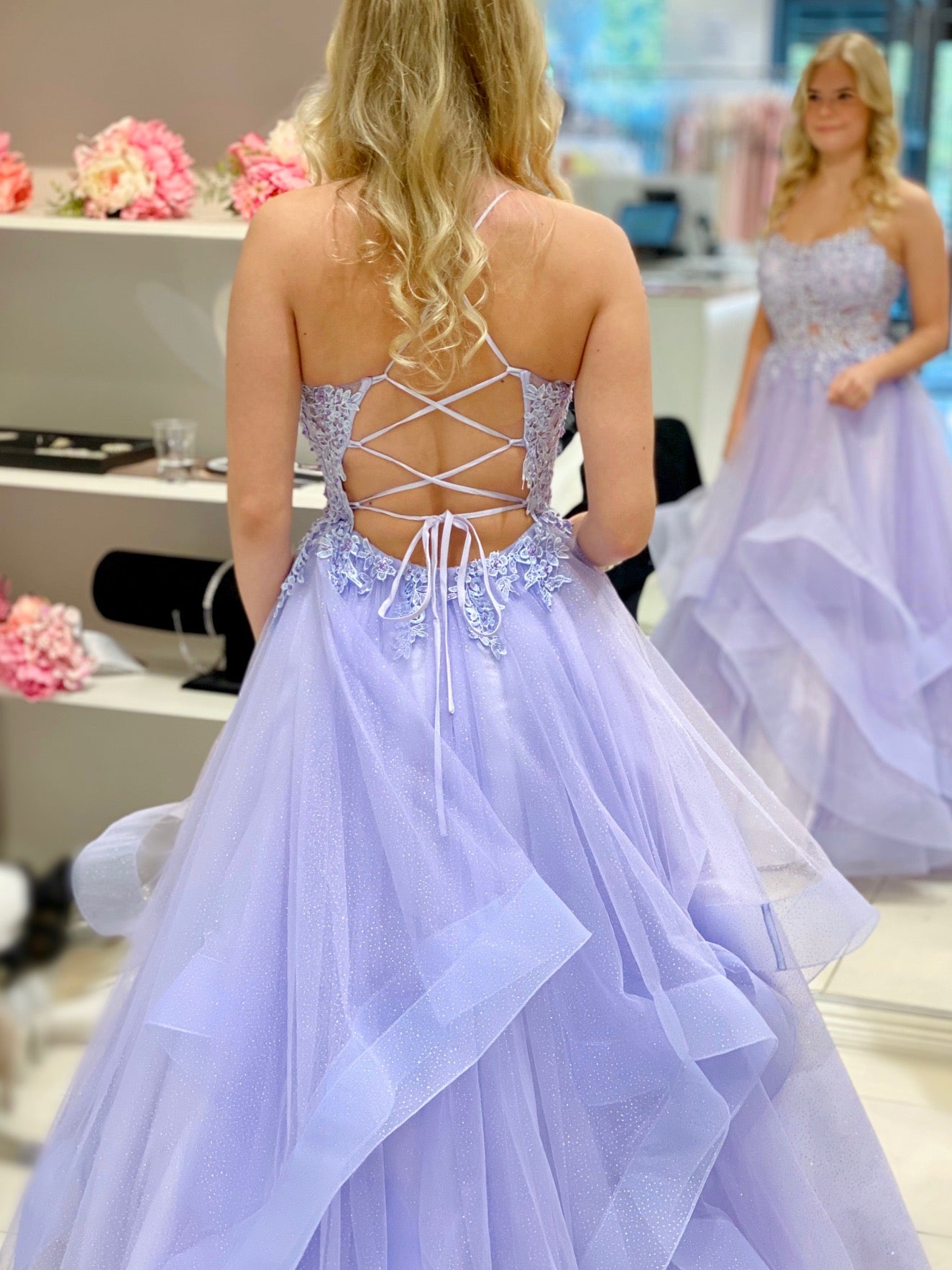 Violetti vanhojentanssimekko, röyhelöhelma ja pitsikoristeltu yläosa.