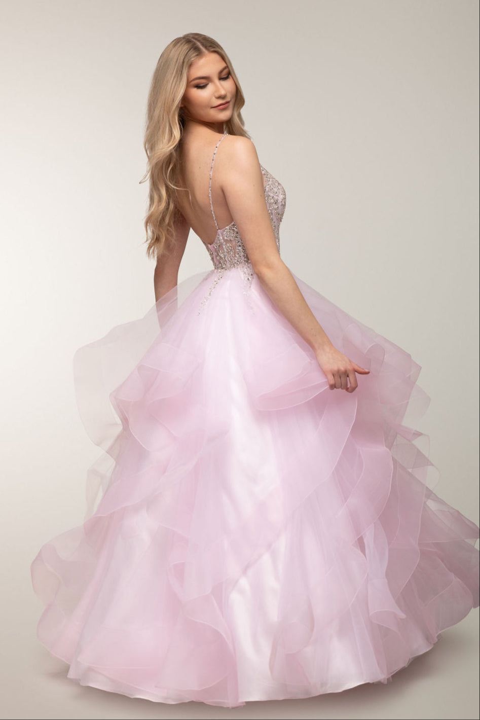 Vaaleanpunainen vanhojentanssimekko kirjailtua yläosa ja röyhelöhelma, takaa.