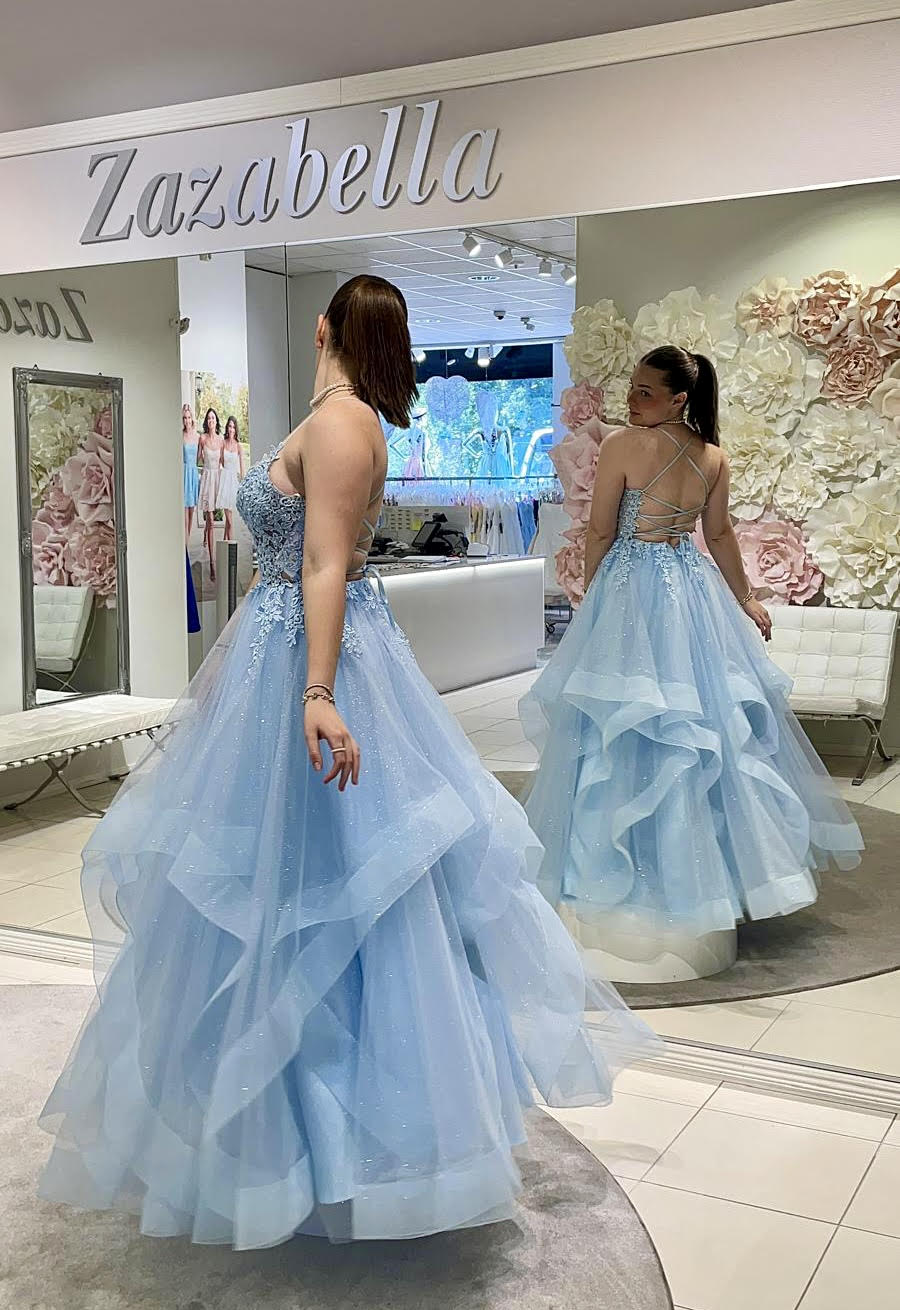 Vaaleansininen vanhojentanssimekko röyhelöhelmalla ja pitsiyläosalla, peilin kautta kuva.