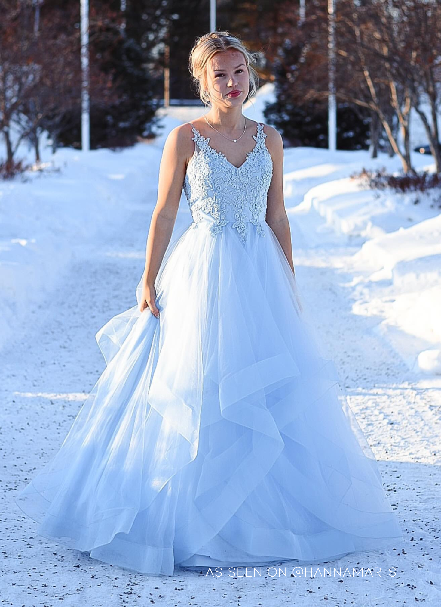 Vaaleansininen vanhojentanssimekko pitsiyläosalla ja röyhelöhelmalla, edestä.