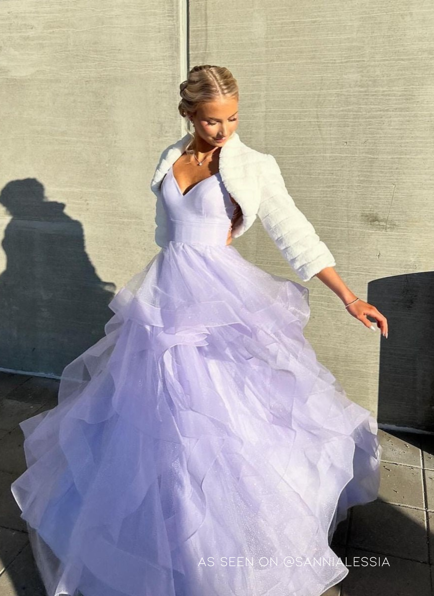 Violetti vanhojentanssimekko kimaltavalla röyhelöhelmalla ja avoimella selällä, edestä.