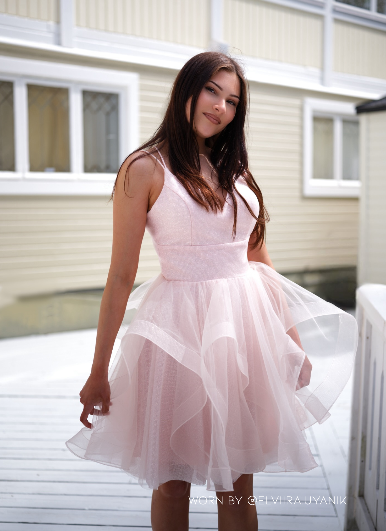 Näyttävä vaaleanpunainen juhlamekko kimaltavalla pinnalla.