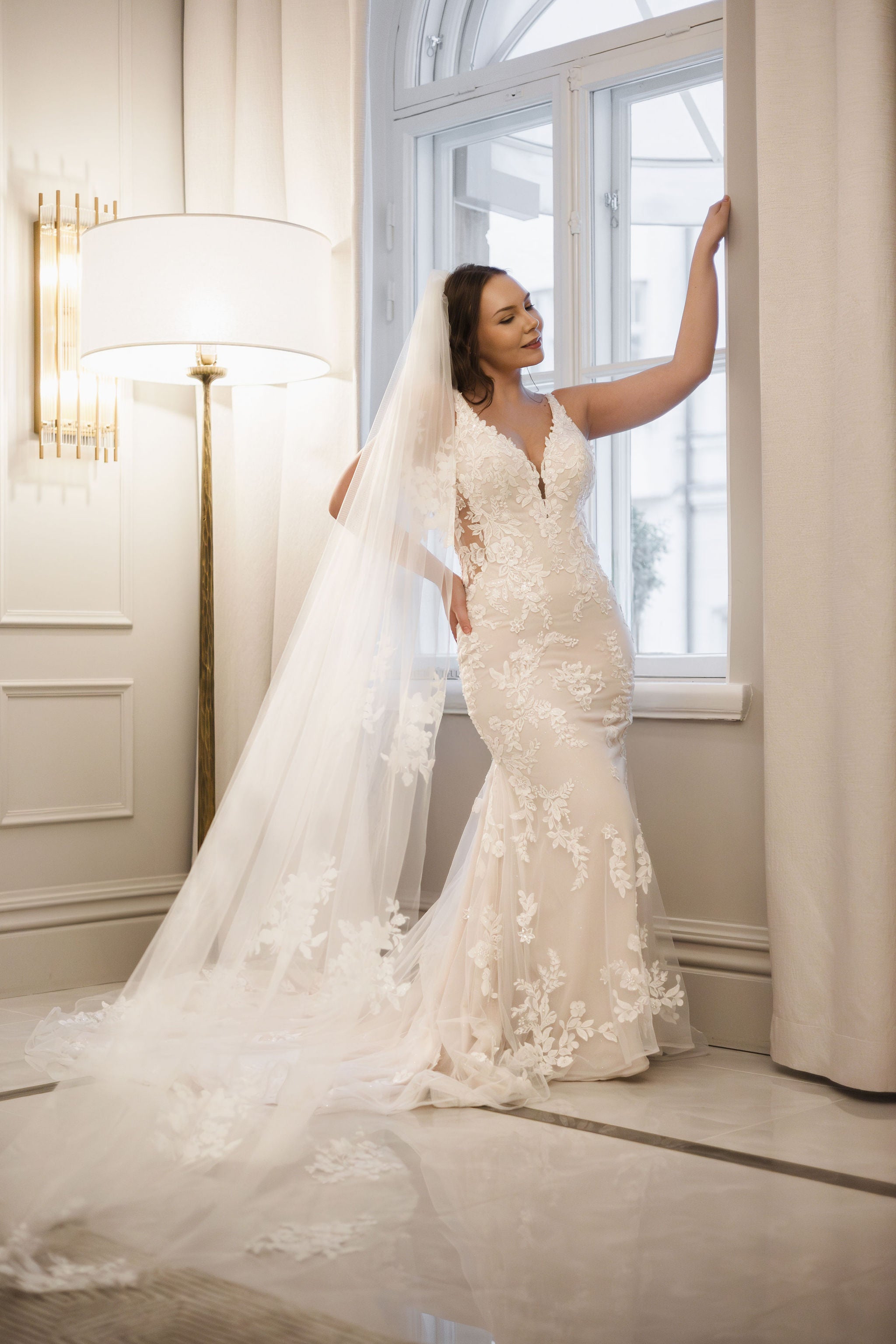 Merenneitomallinen häämekko pitsikoristeluilla, koristelluilla olkaimilla, nude pohjakankaalla ja laahuksella, edestä.