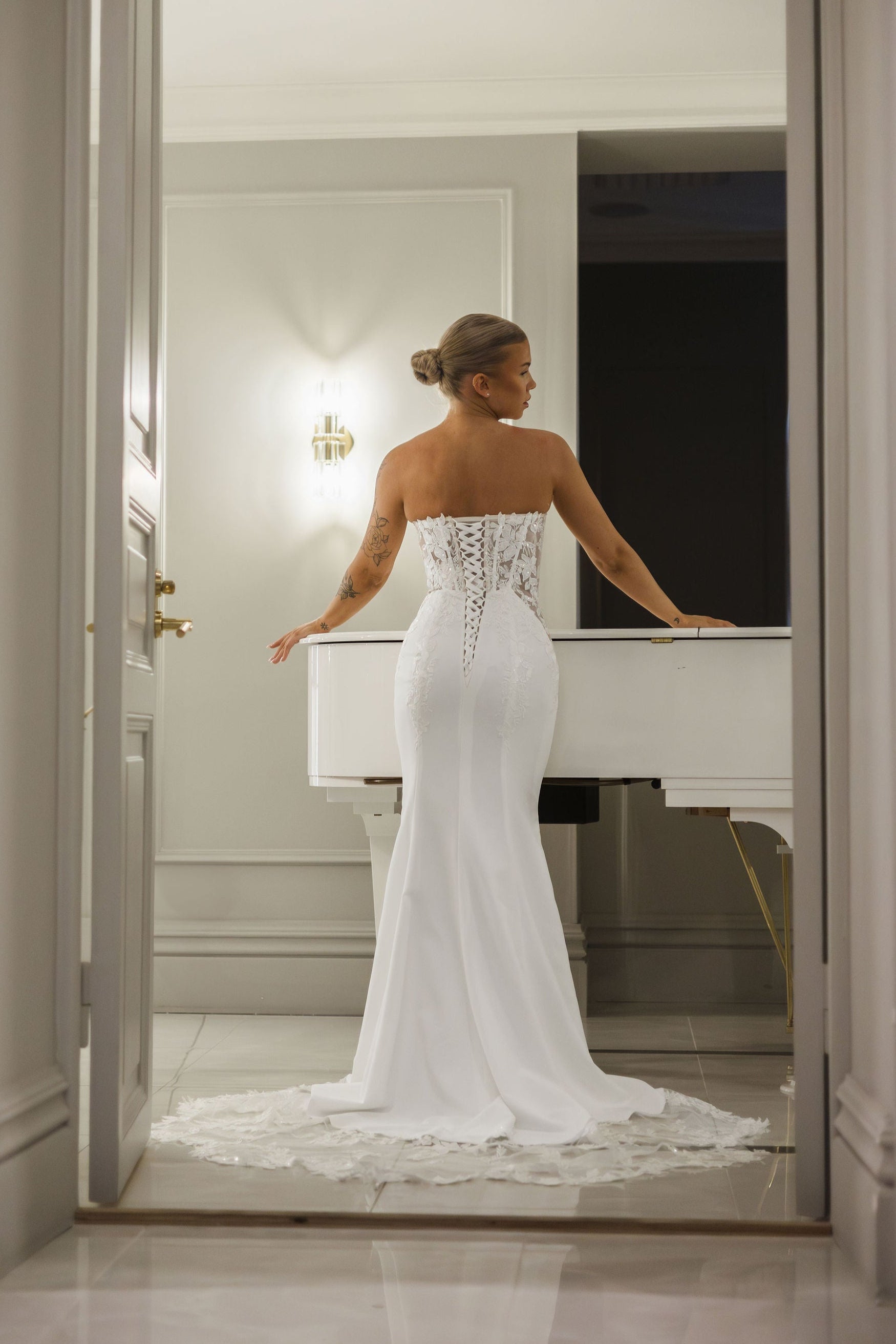 Olkaimeton tyköistuva häämekko korsettirakenteella ja kauniilla laahuksella, takaa.