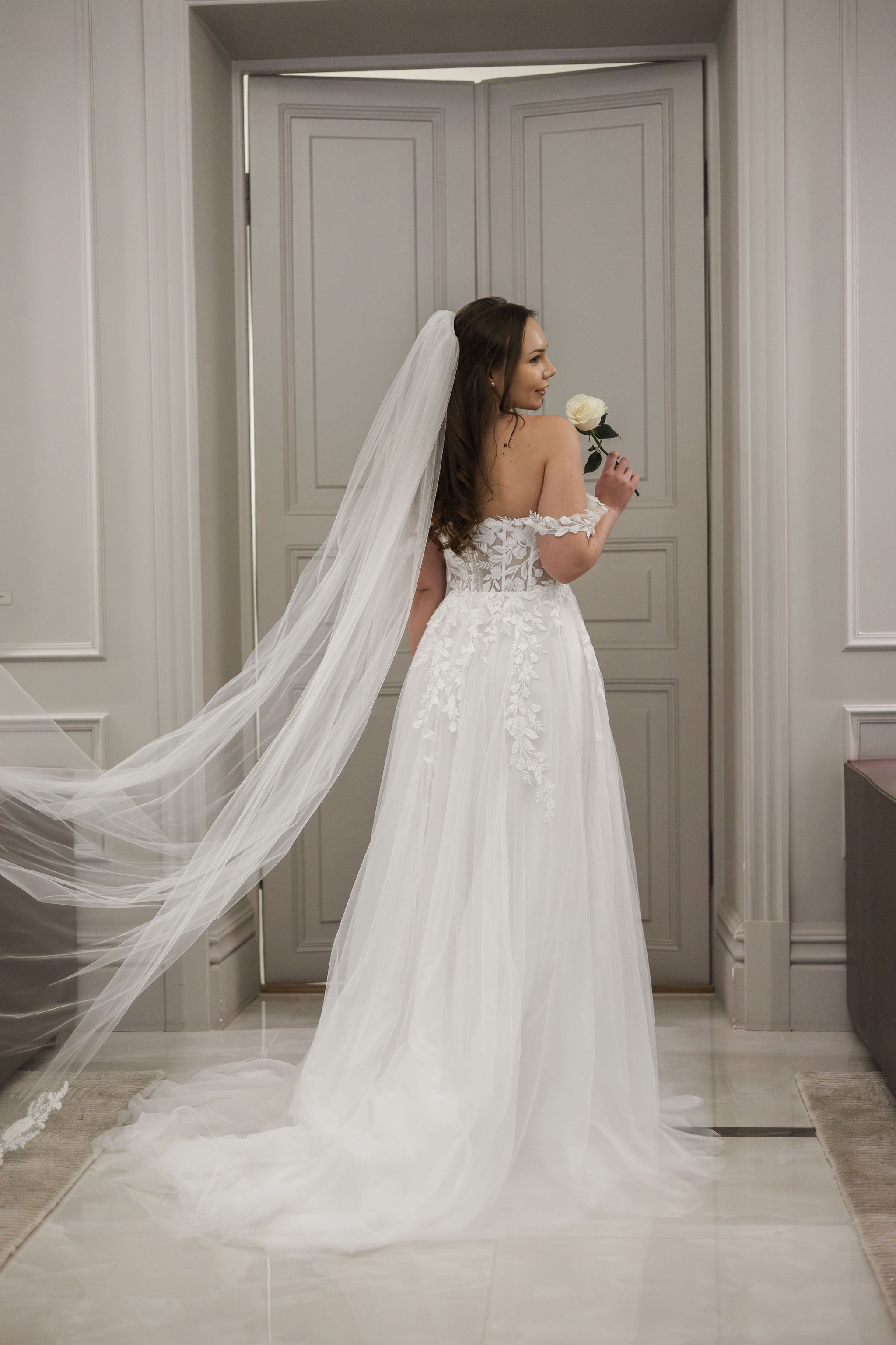 Häämekko pitsiyläosalla, läpikuultava selkä ja näyttävä tyllilaahus.