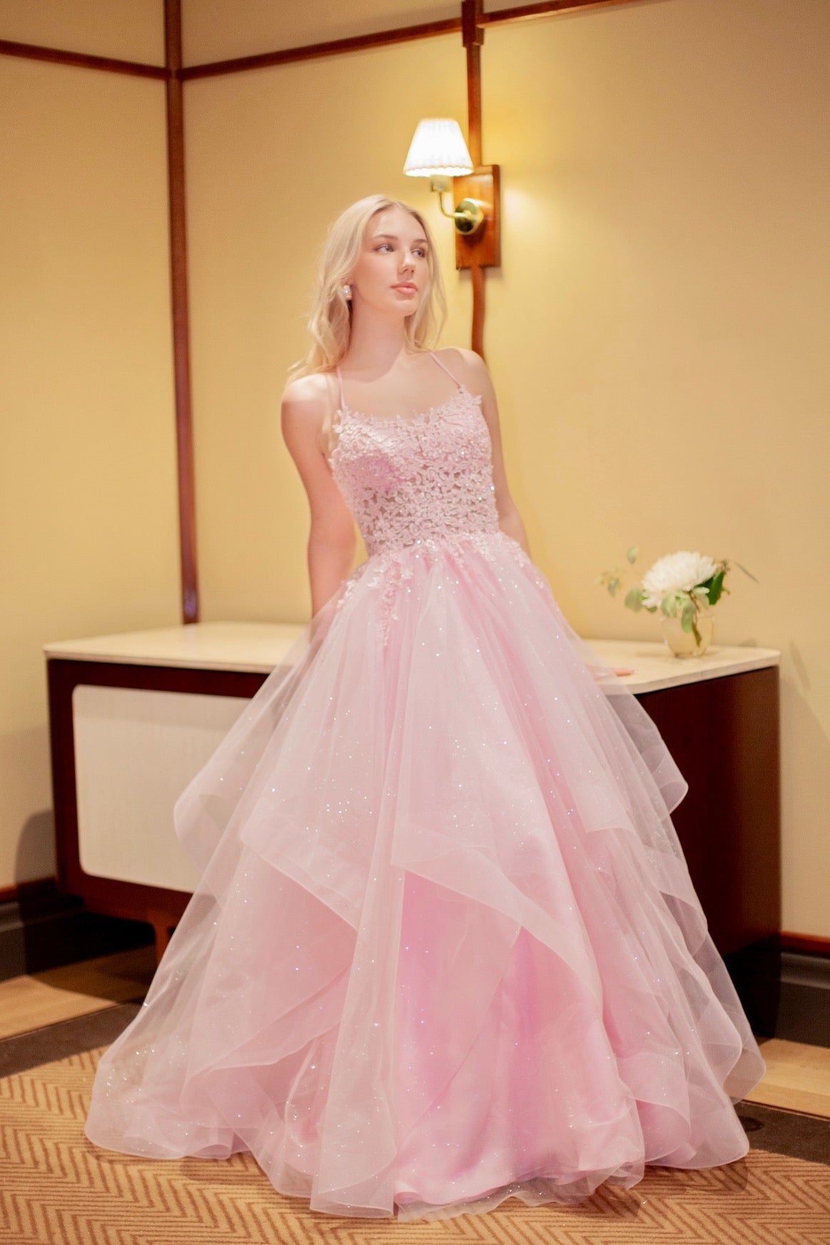 Vaaleanpunainen vanhojentanssimekko röyhelöhelmalla ja kimaltava.