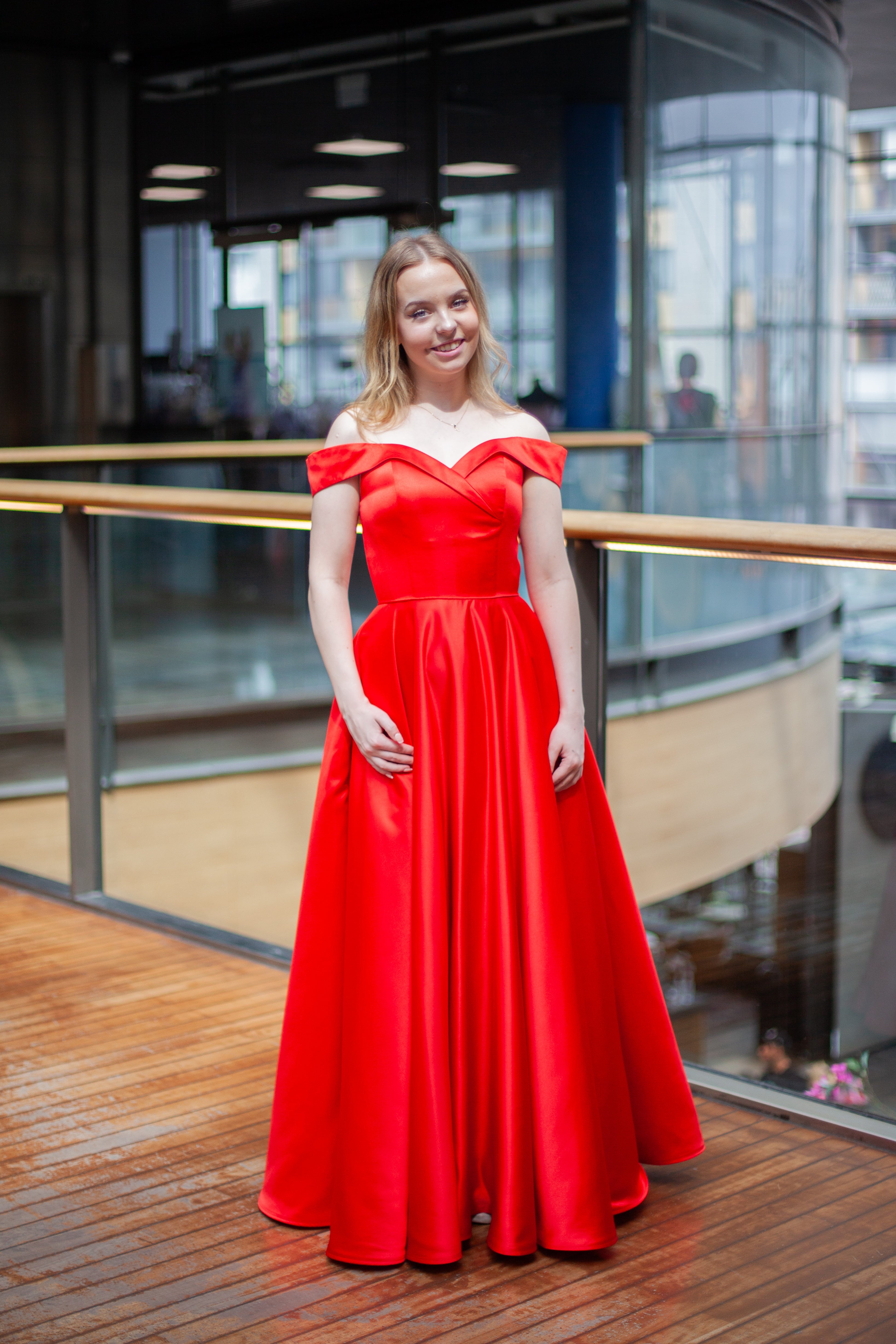 Punainen vanhojentanssimekko off shoulder -olkaimilla ja kauniisti laskeutuvalla helmalla.