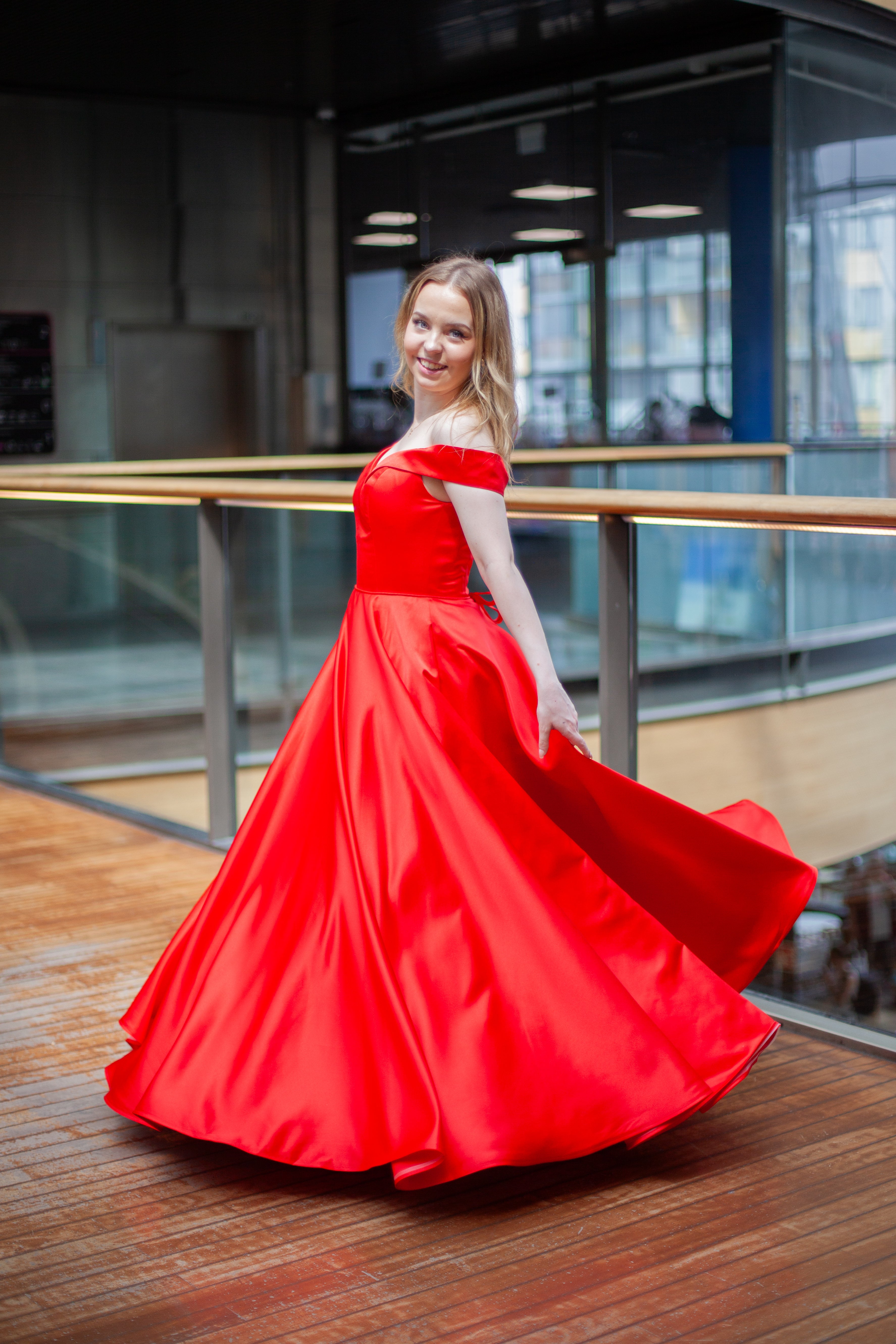 Punainen vanhojentanssimekko off shoulder -olkaimilla ja kauniisti laskeutuvalla helmalla.