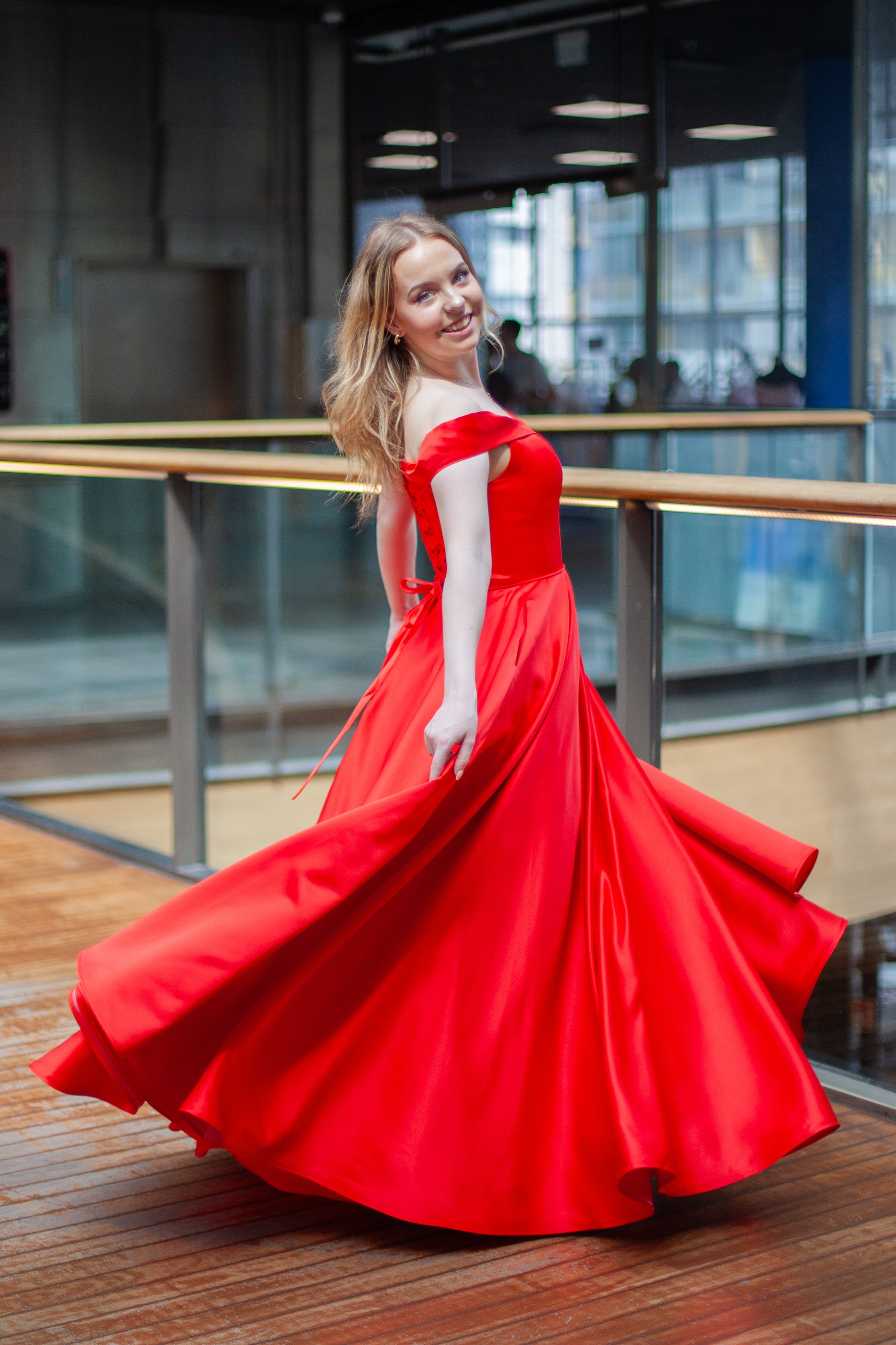 Punainen vanhojentanssimekko off shoulder -olkaimilla ja kauniisti laskeutuvalla helmalla.