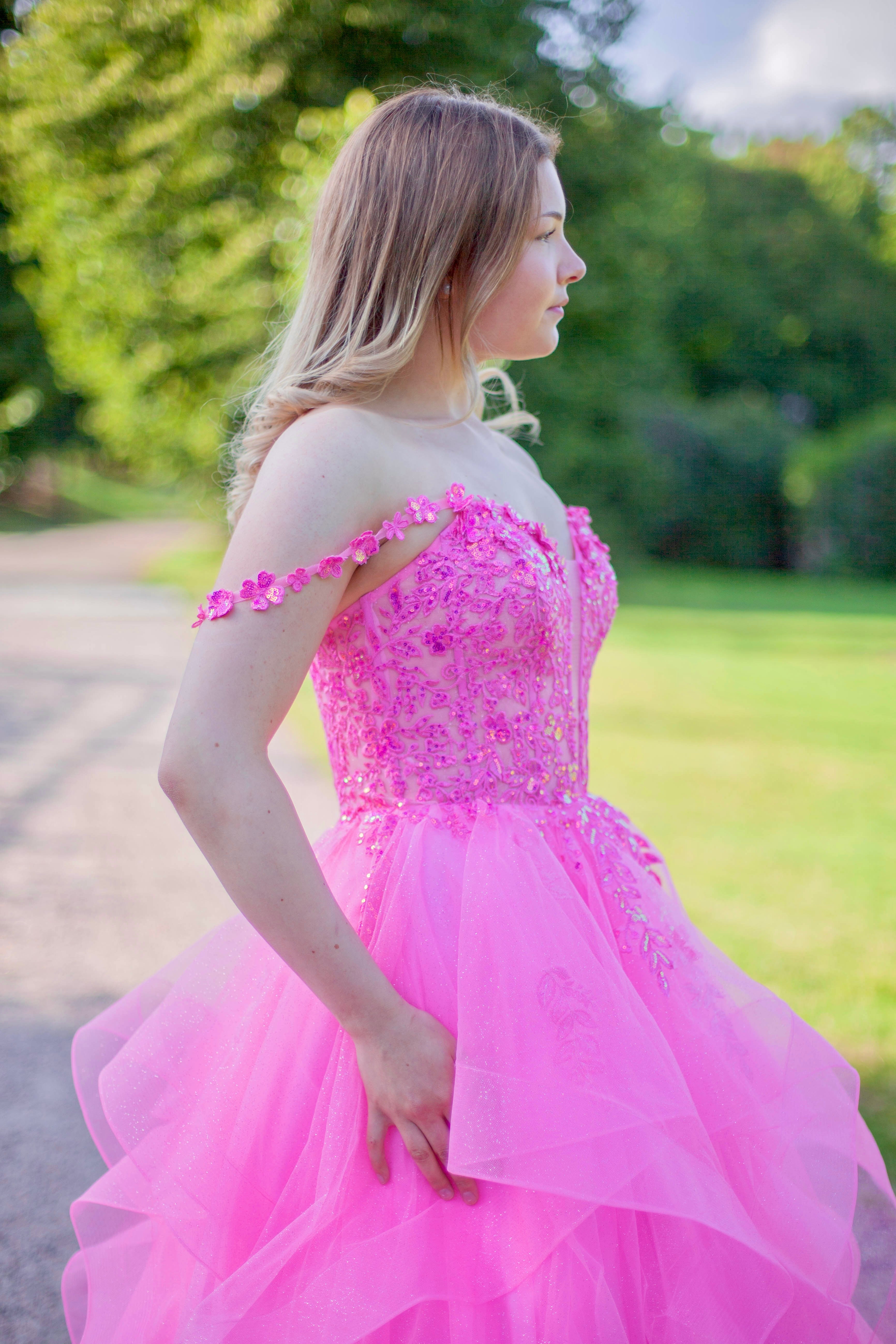 Pinkki vanhojentanssimekko röyhelöhelmalla ja off shoulder olkaimella. 