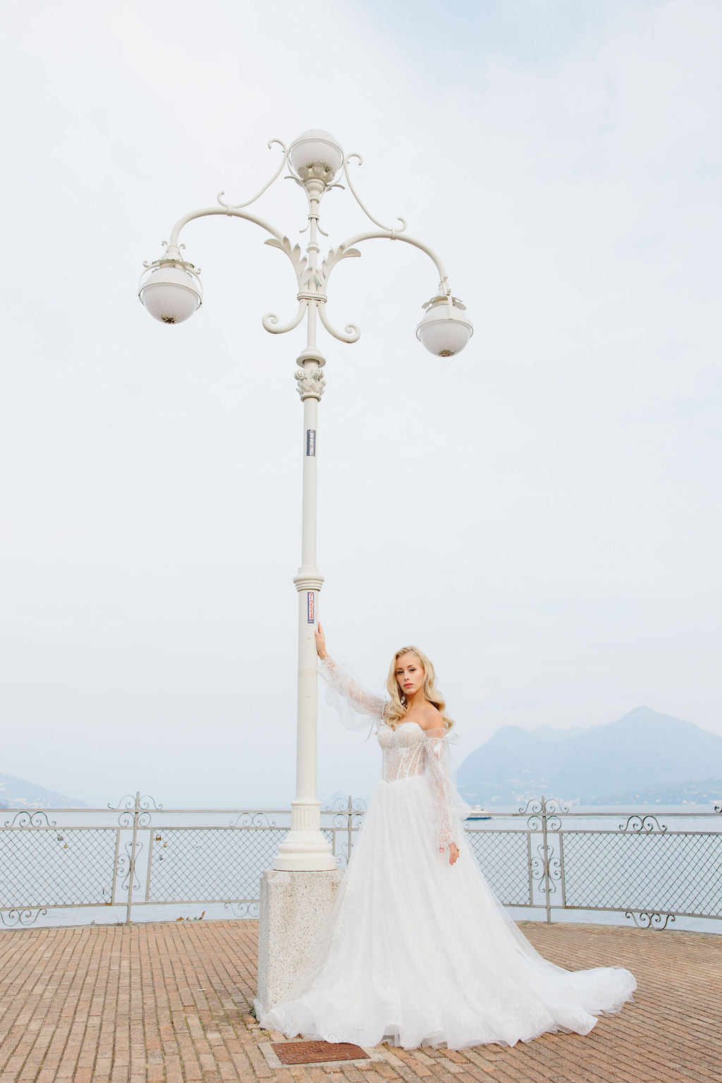 Häämekko korsettimaisella yläosalla ja pitsisillä hihoilla.