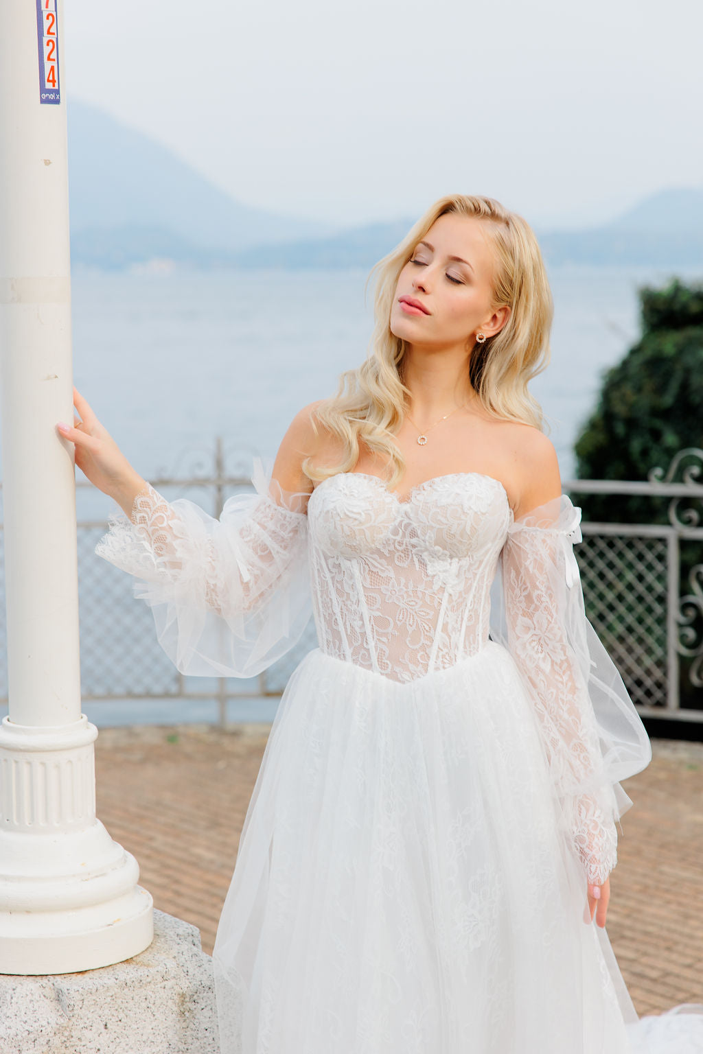 Häämekko korsettimaisella yläosalla ja pitsisillä hihoilla.